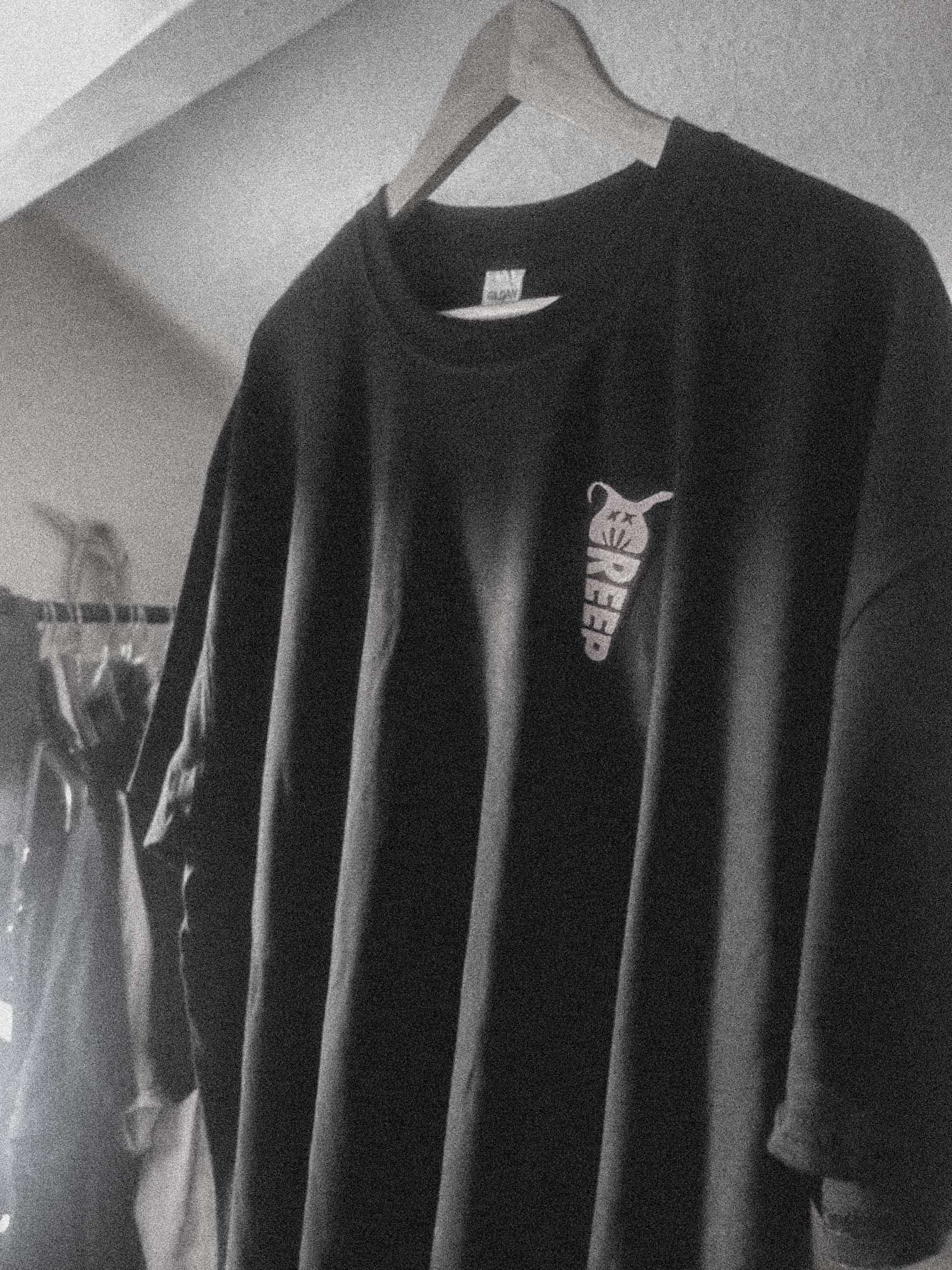 black t-shirt of streetwear branidng on clothes hanger in black & white.