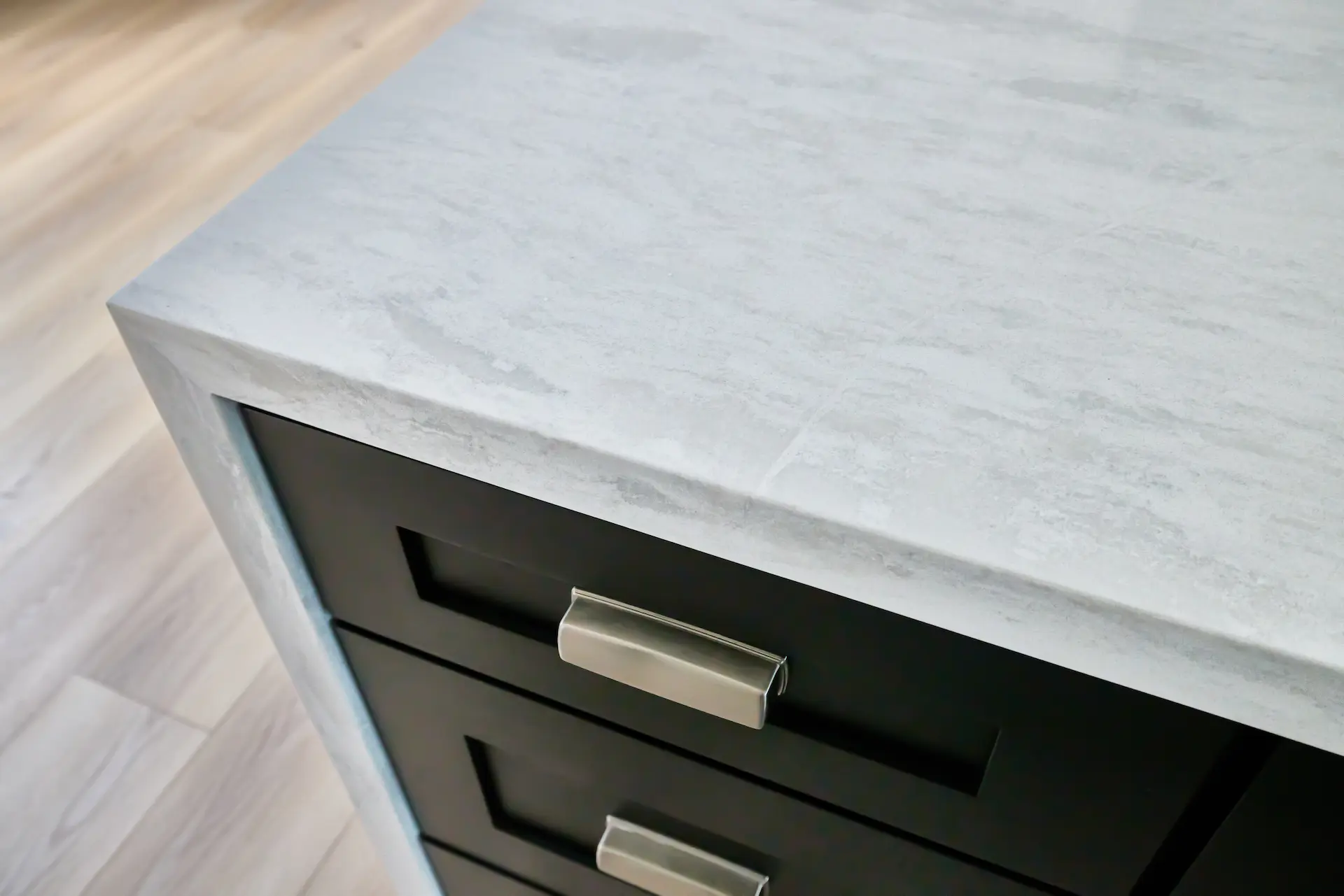 Close-up of the kitchen countertop and cabinet drawers in ADU Orange, showcasing the sleek black finish and contemporary design. Photo by Todd Huge.