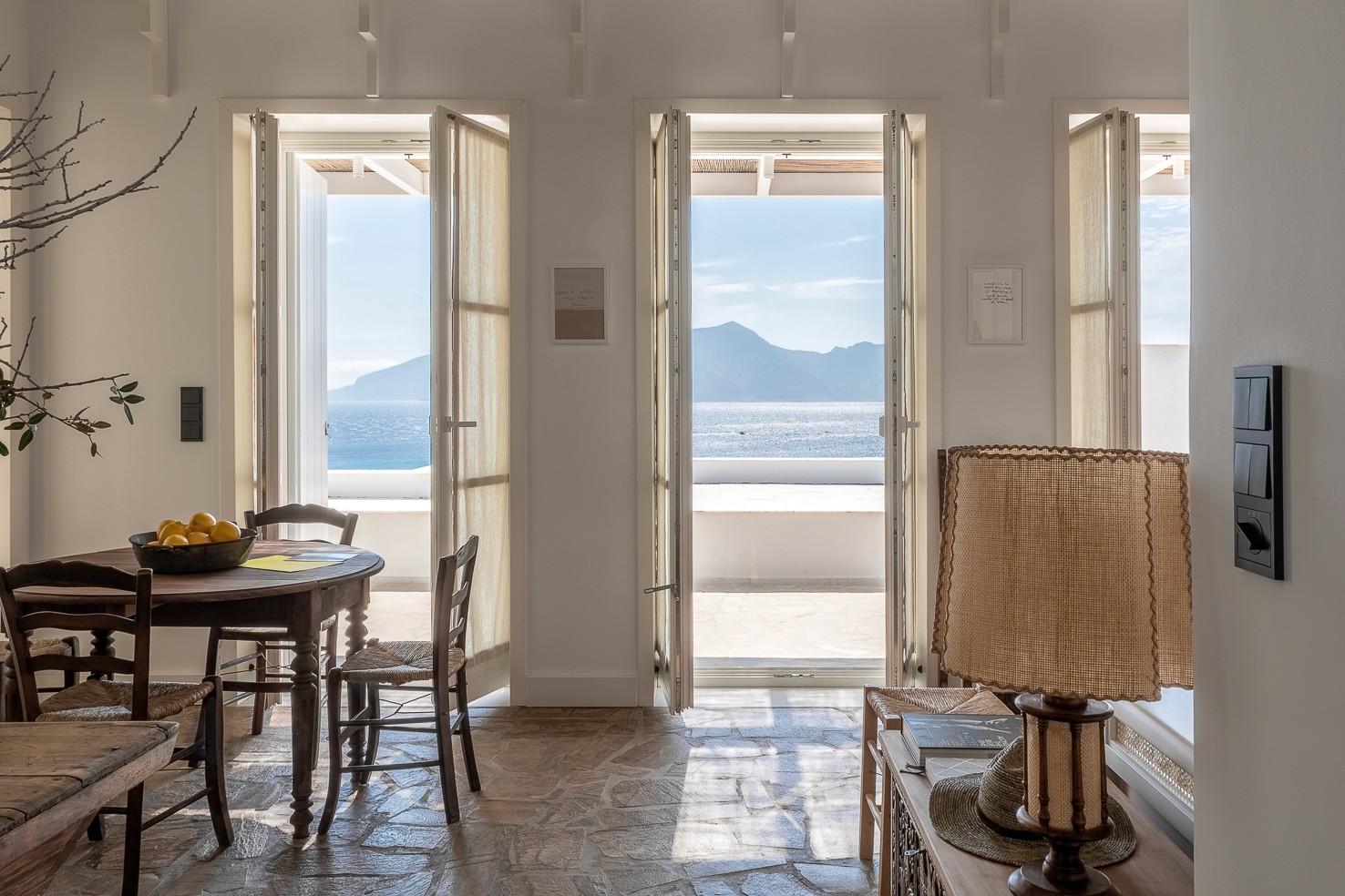 A living room looking out onto the see and the neighbouring island in the Greek mediterenean off Koufonisia