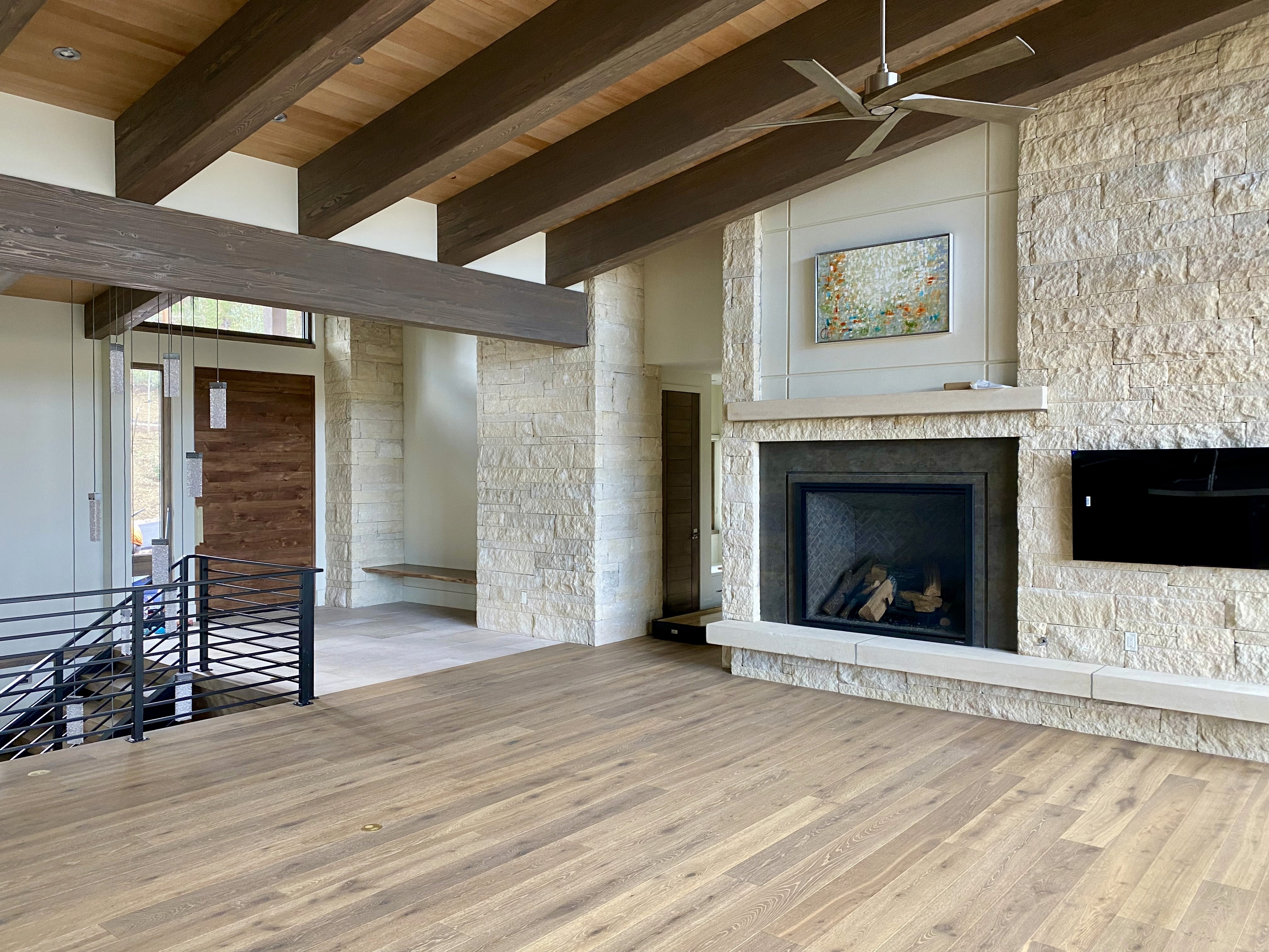 Modern House interior with exposed beams and stone fireplace