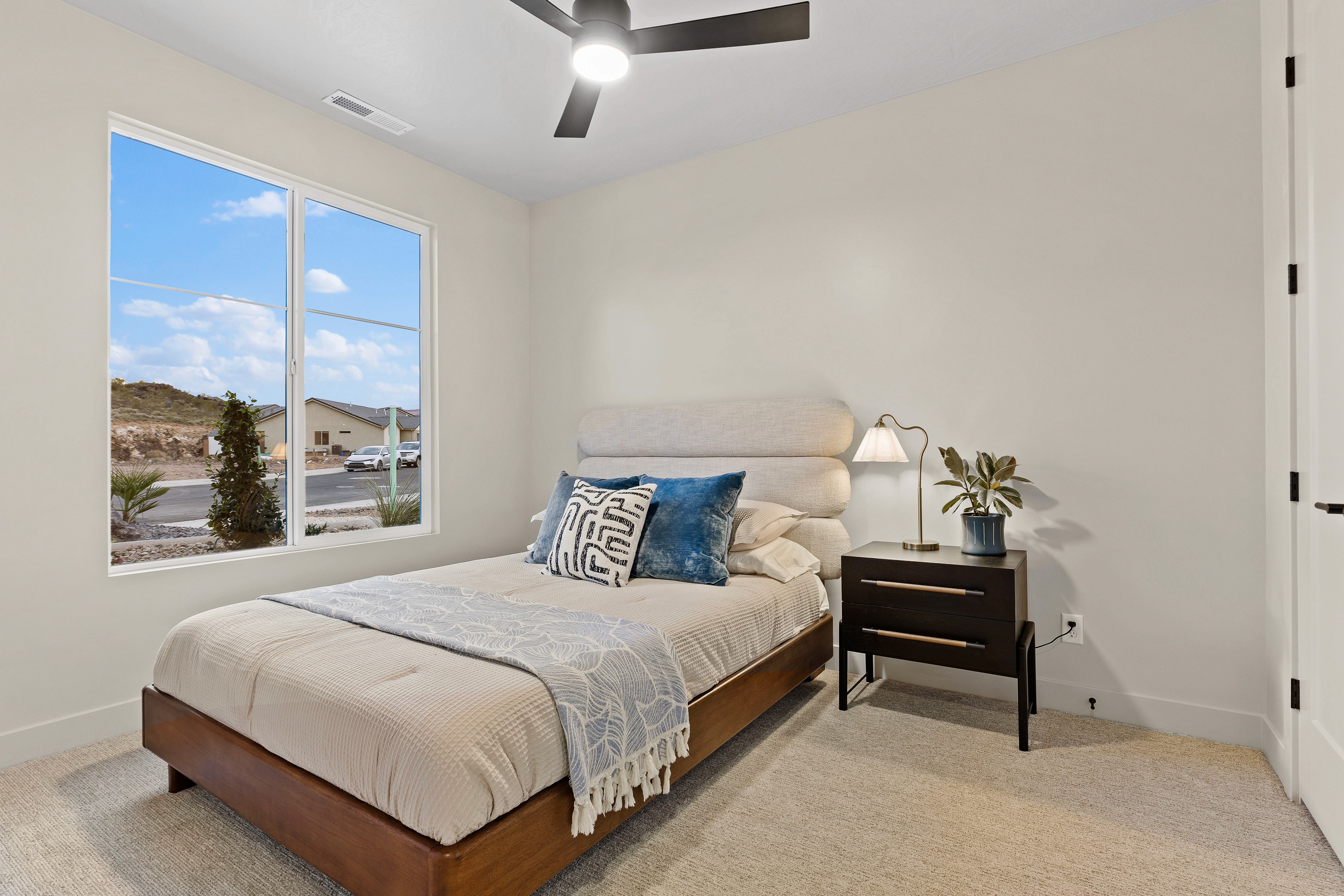 Secondary bedroom inside The Painted Horizon twin home in Hurricane, Utah designed with simple, functional finishes.