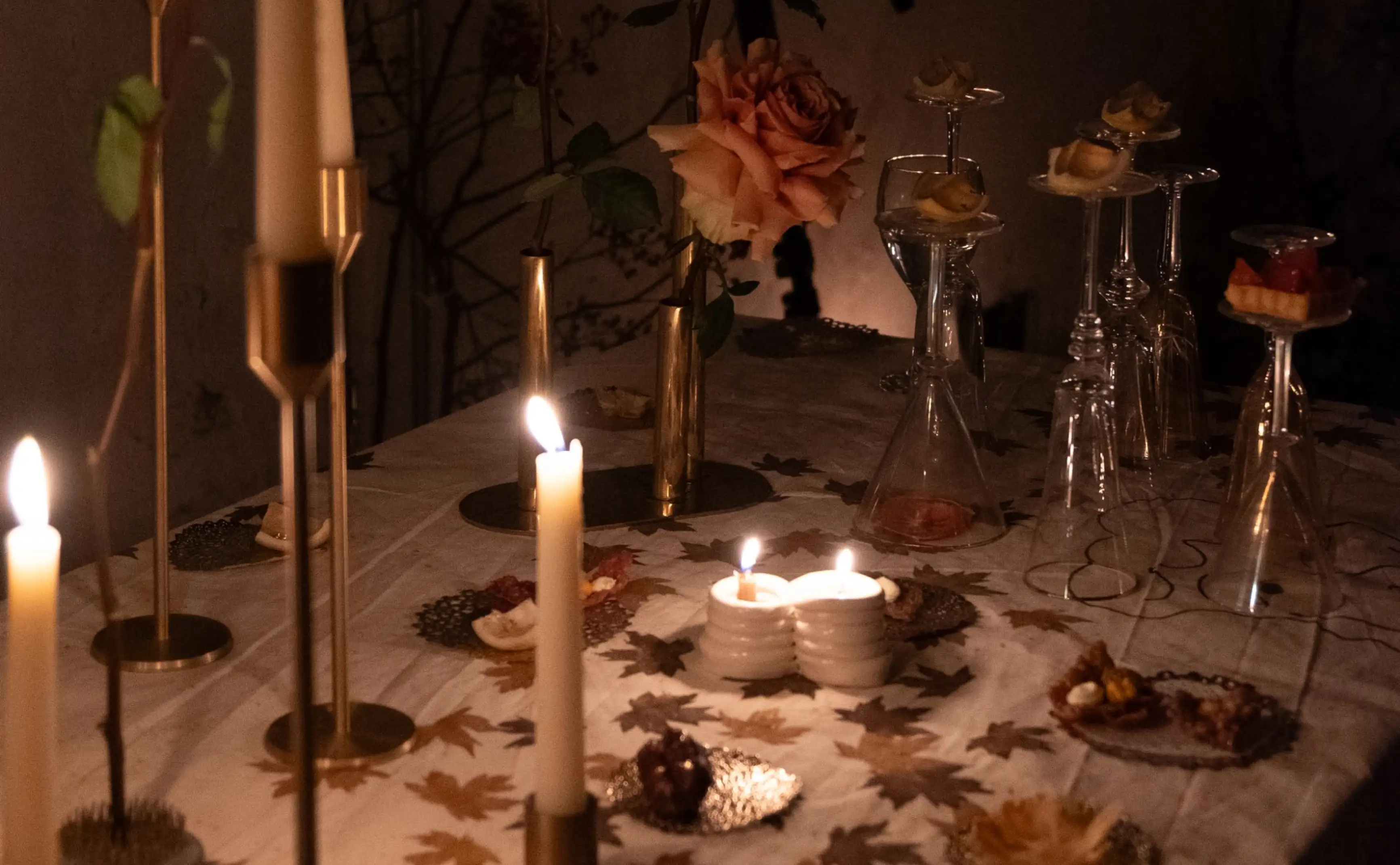 Mesa iluminada con velas y flores secas para ambientación nocturna artística, creando atmósfera íntima y contemplativa.