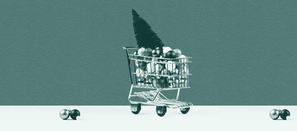 Mini shopping cart filled with Christmas ornaments and a small tree, symbolizing holiday shopping and seasonal marketing.