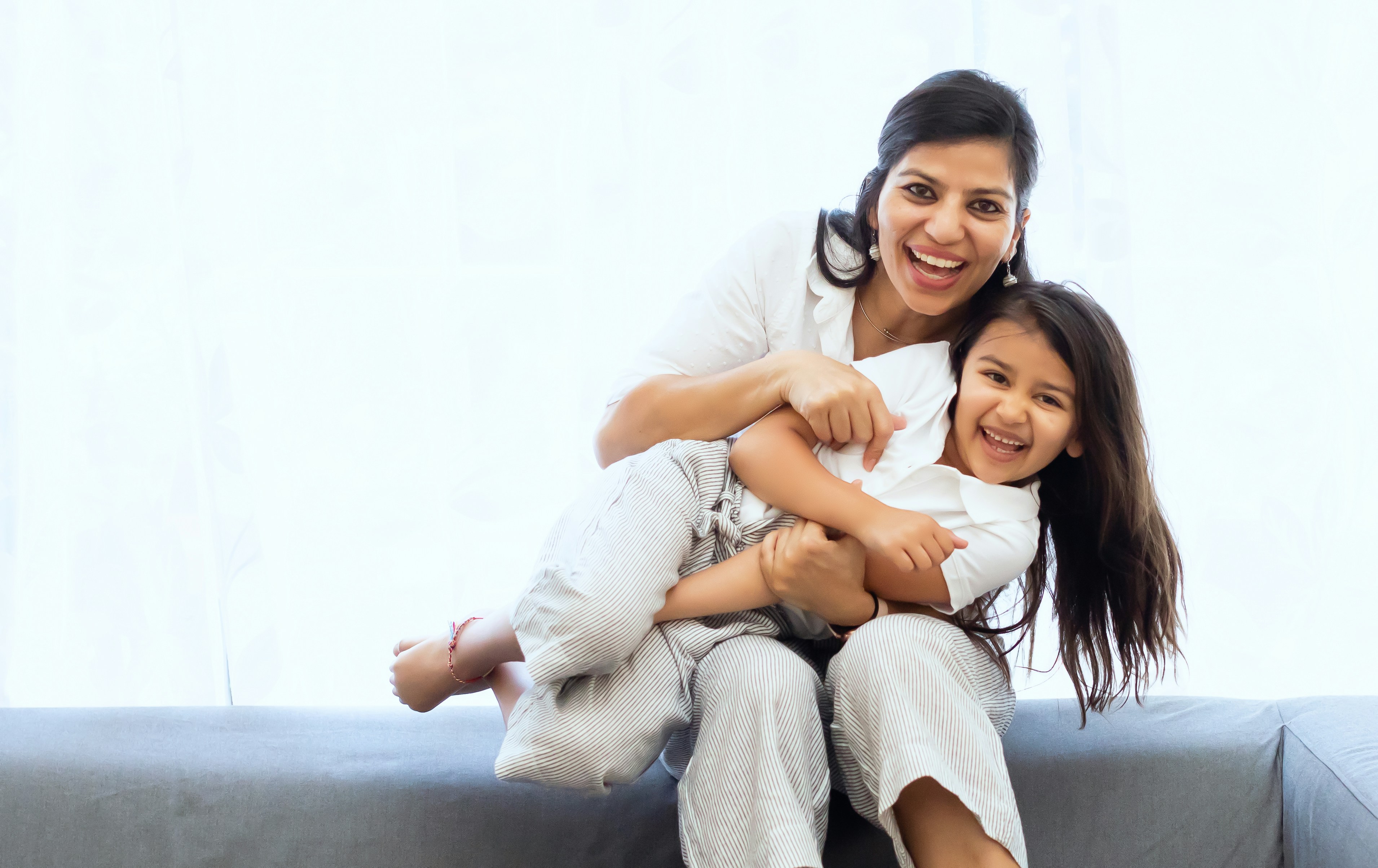 a woman sitting on the floor with a little girl