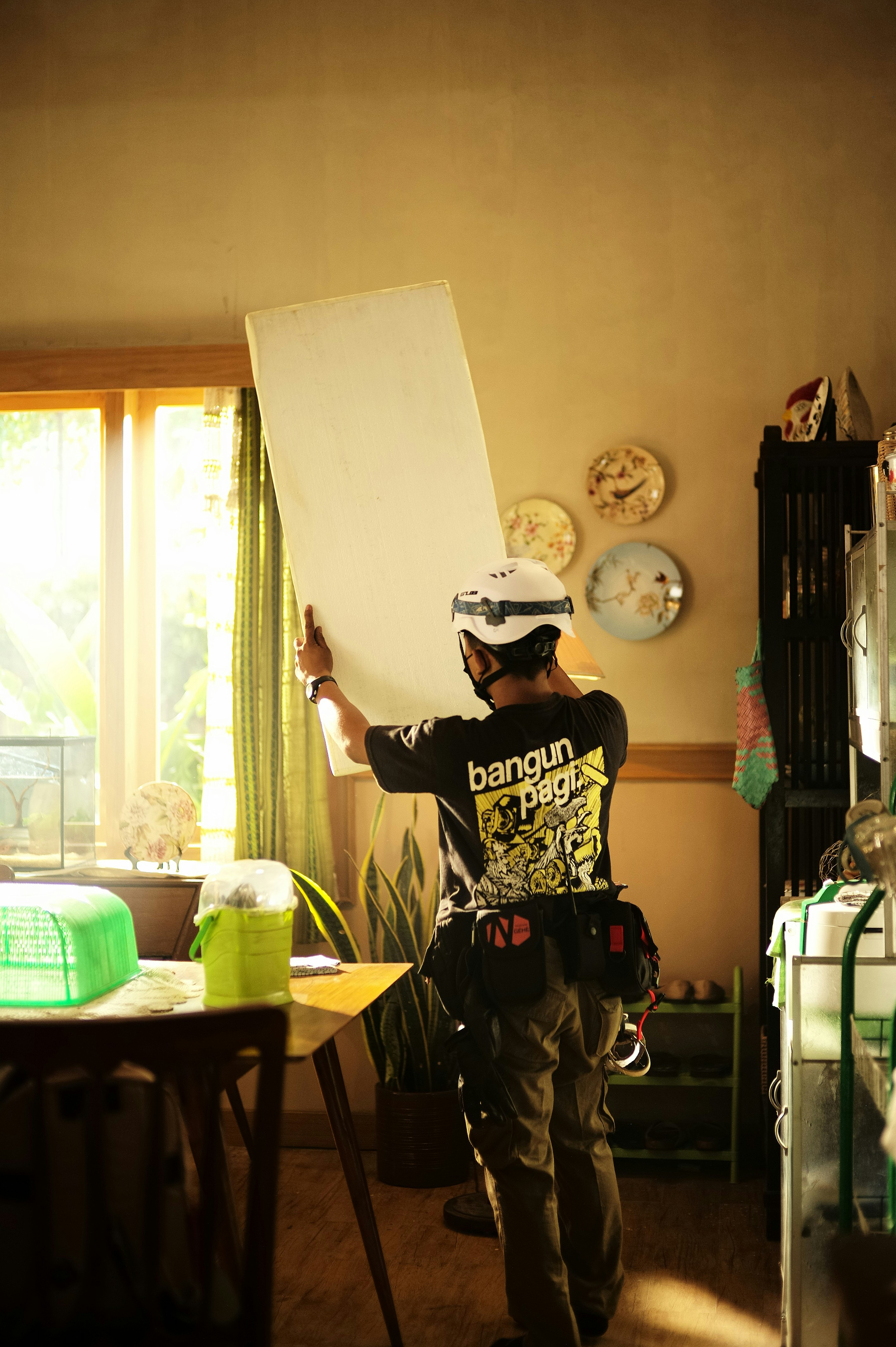 a man wearing a helmet and holding a white board