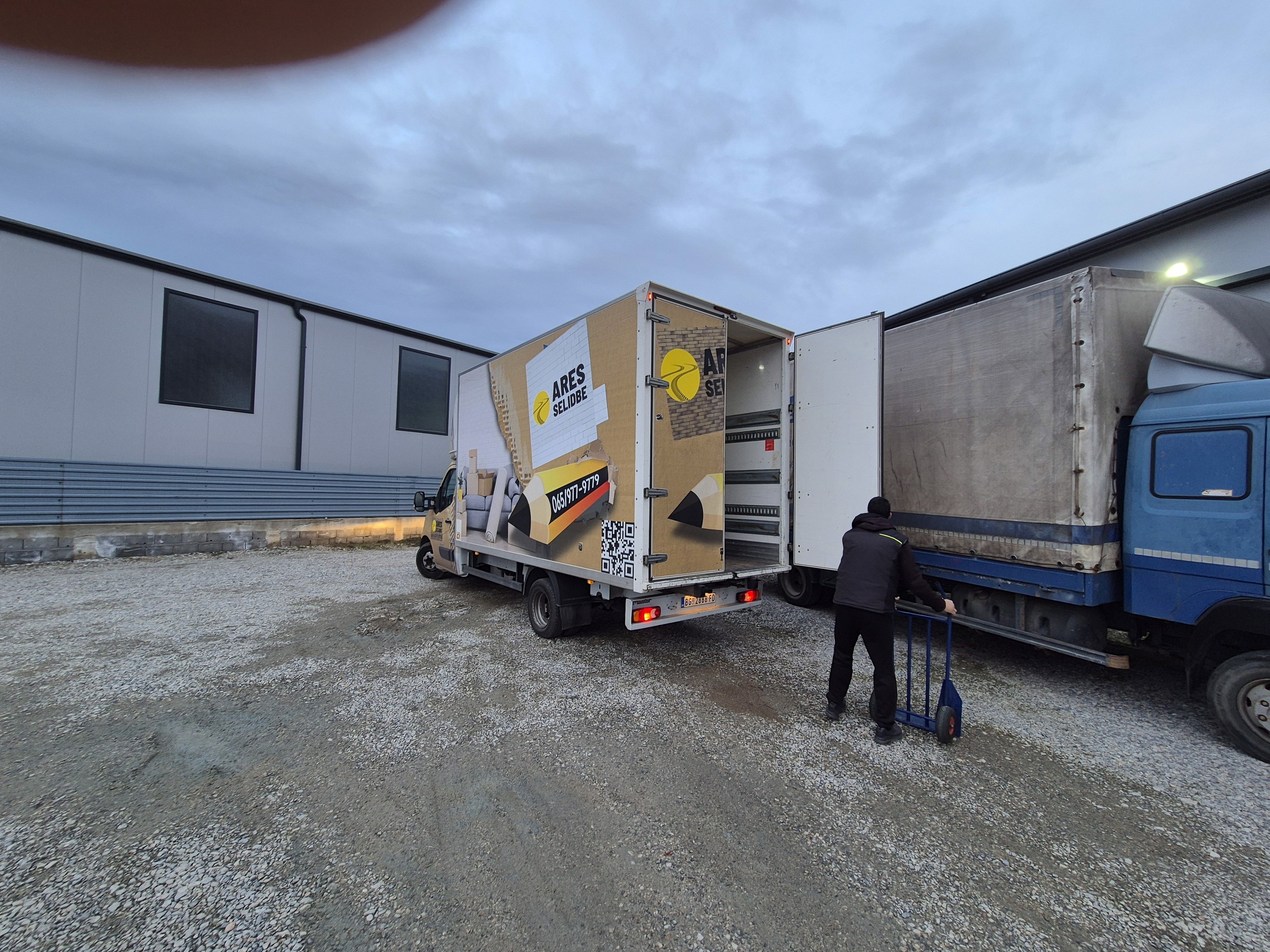 Kamion za selidbe Ares Selidbe sa otvorenim tovarnim prostorom tokom utovara i istovara u industrijskom dvorištu