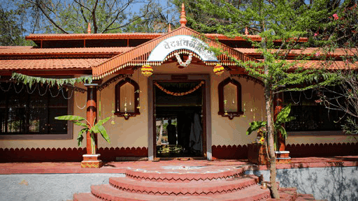 Aerial view of a winding road cutting through rocky terrain and sandy landscape.