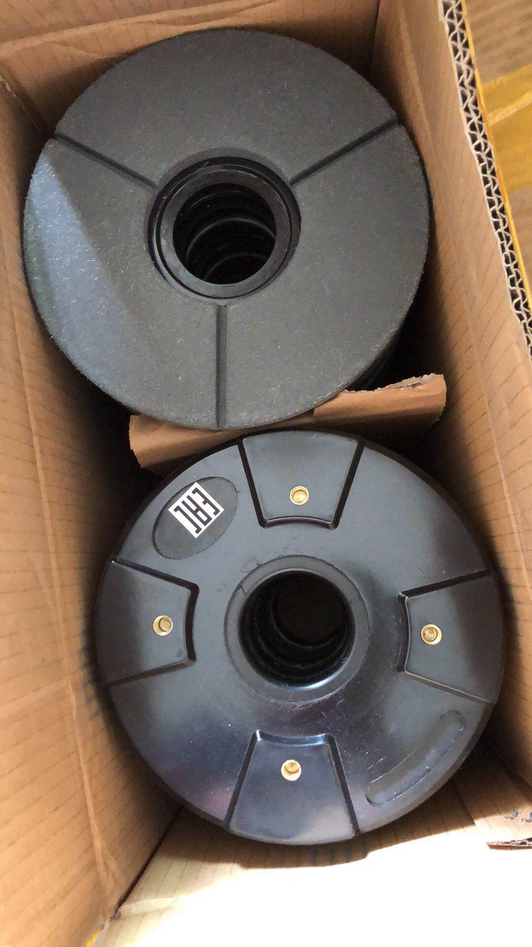 Two black polishing discs inside a cardboard box.