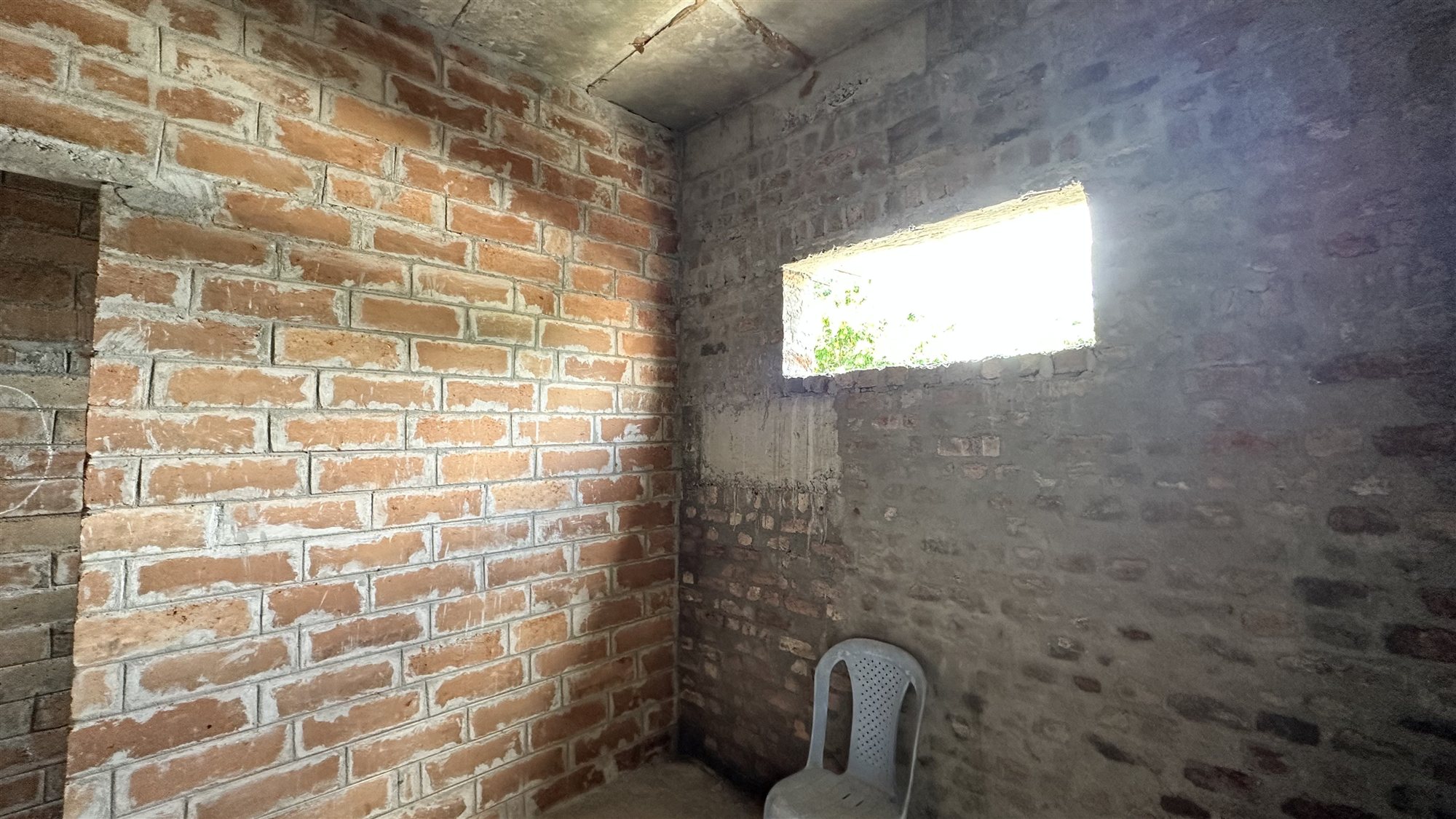 Interior room with warm-toned exposed Agrocrete® block walls and a window