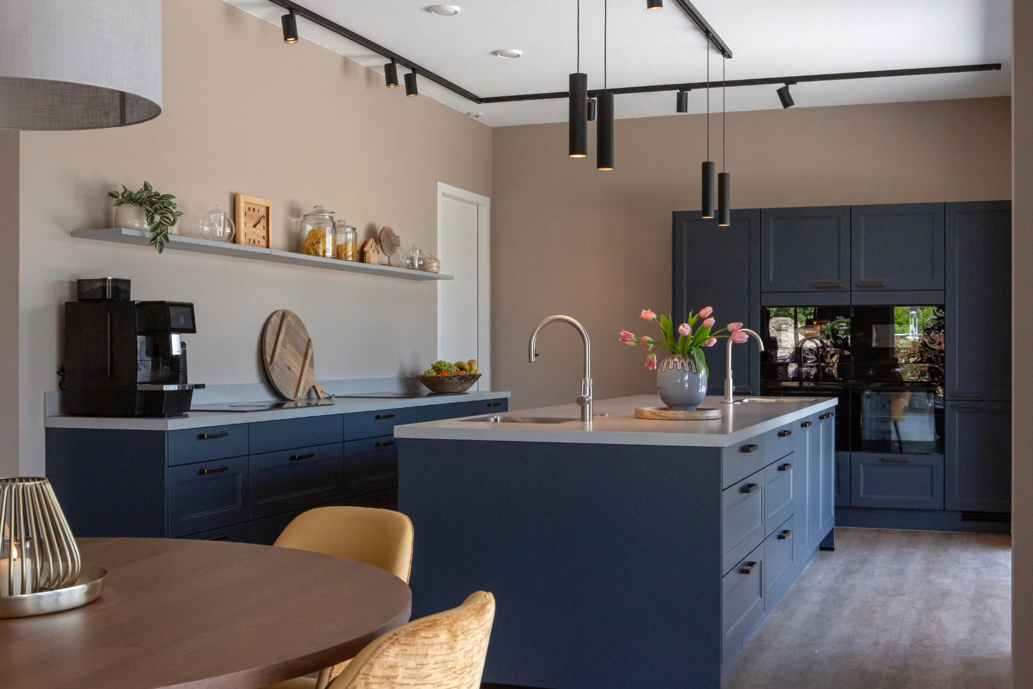 donker blauwe keuken met eiland en hoge kastenwand