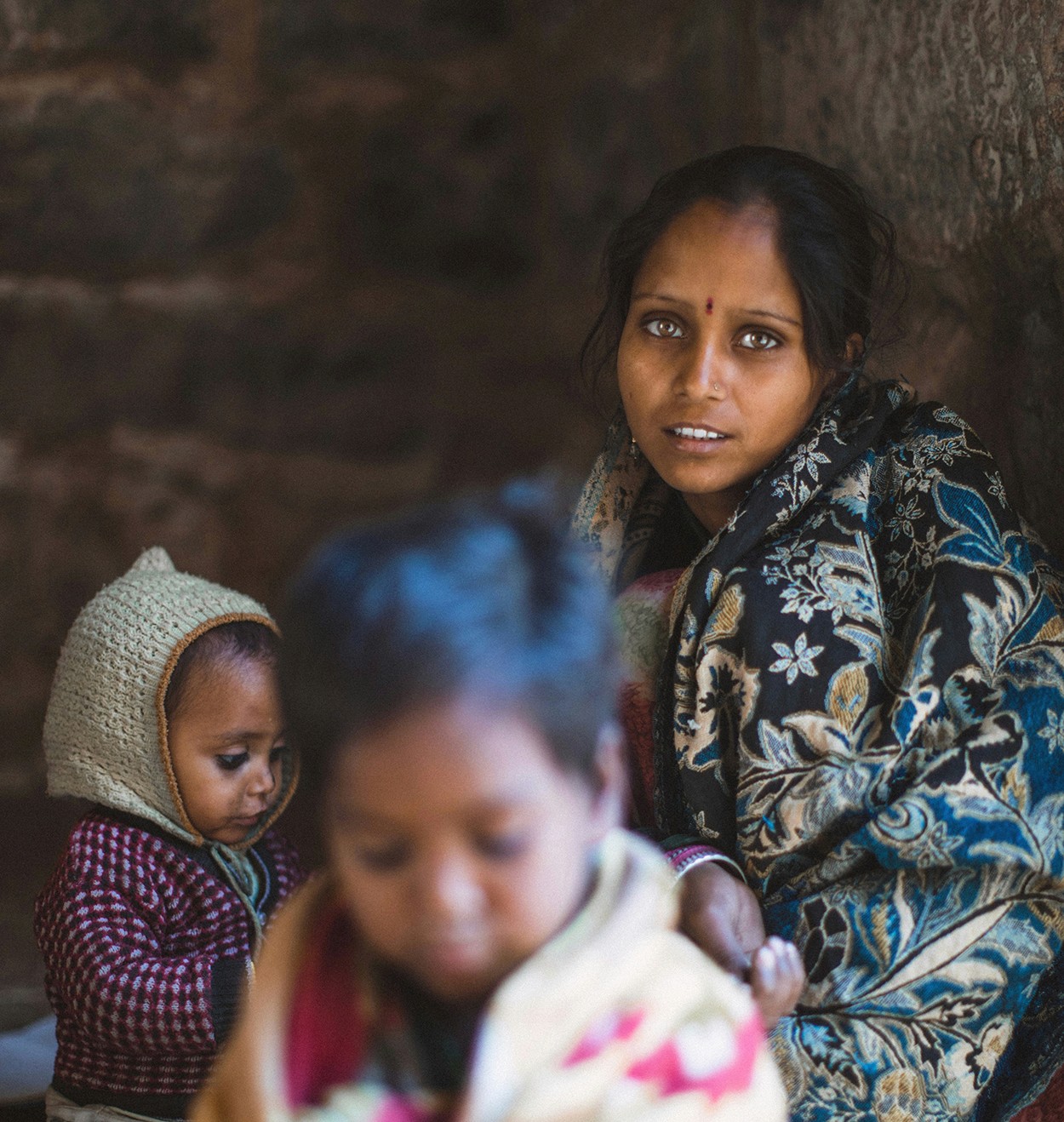 Audience silhouettes in front of a large stage with illuminated screens and lighting at a live event.