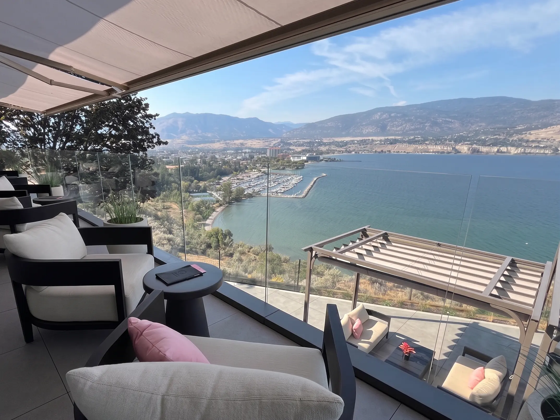 Oceanfront patio with frameless glass railing overlooking water and mountains, representing glass railing installation in Campbell River, BC
