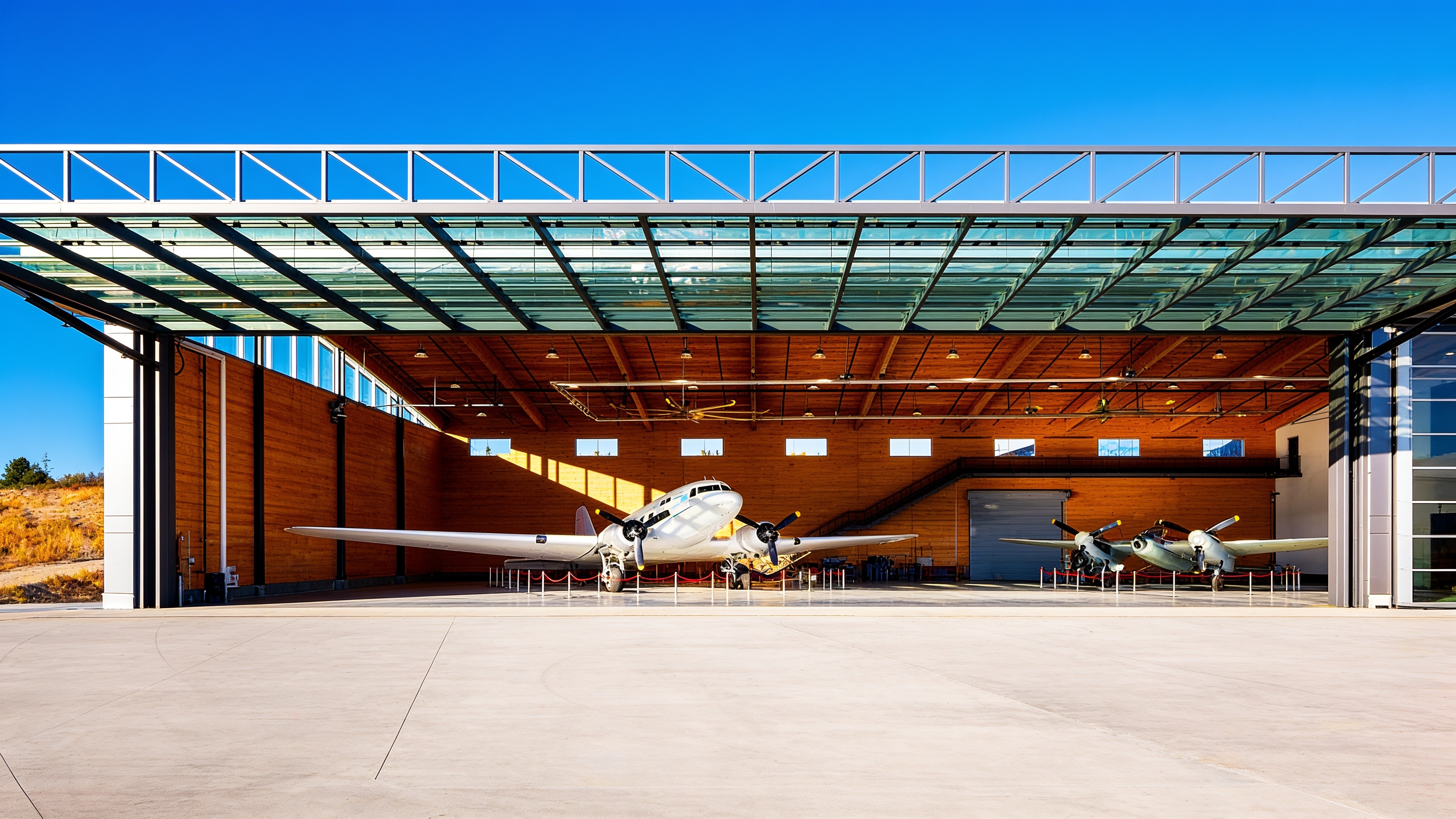 Hangar interior with a vintage aircraft under an open glass hydraulic canopy door