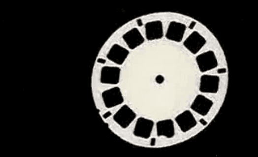 A picture of a white circle with some round and square holes in it.