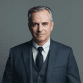 A man in a suit and tie is centered within a round circle.