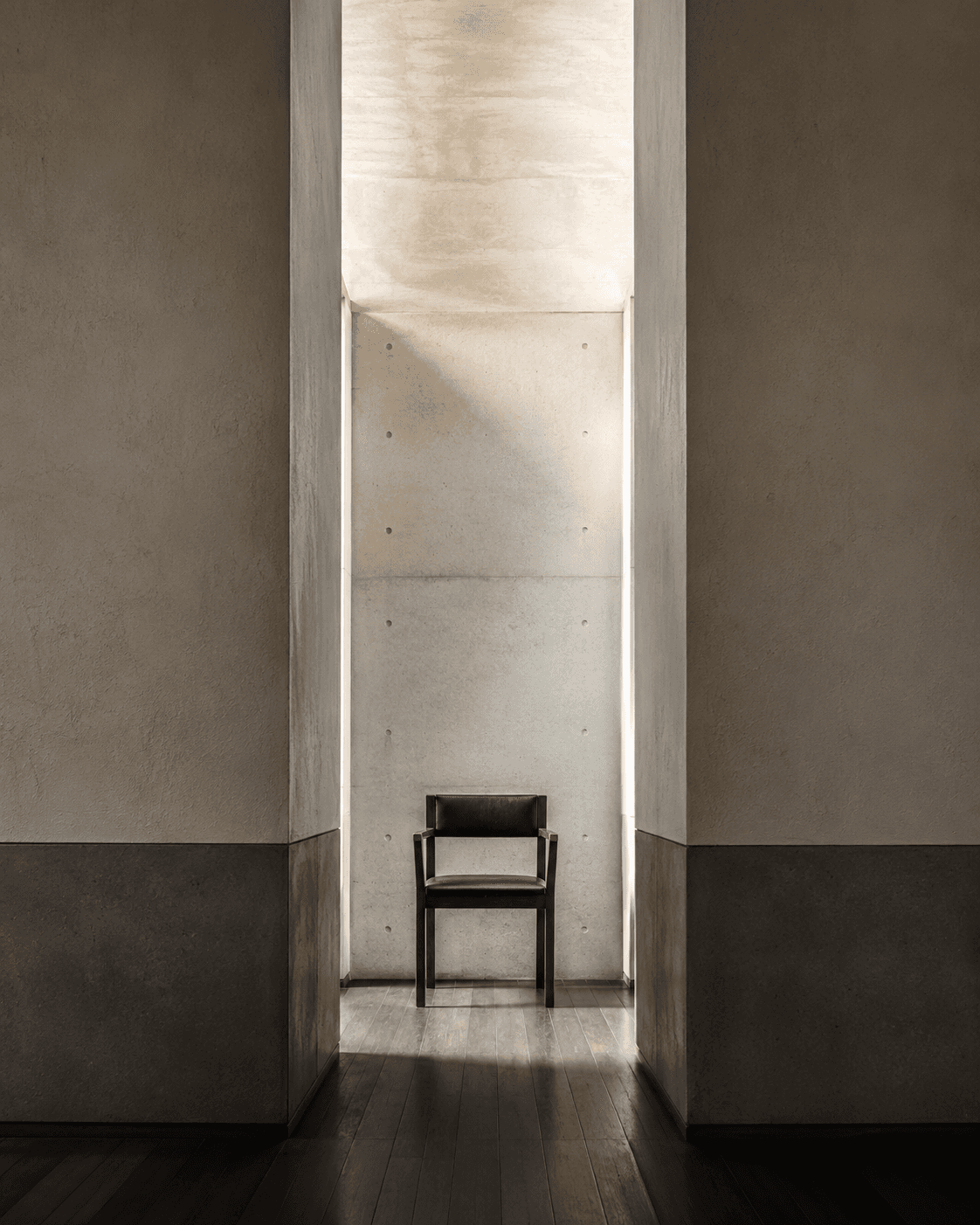 Tall concrete interior with a single chair