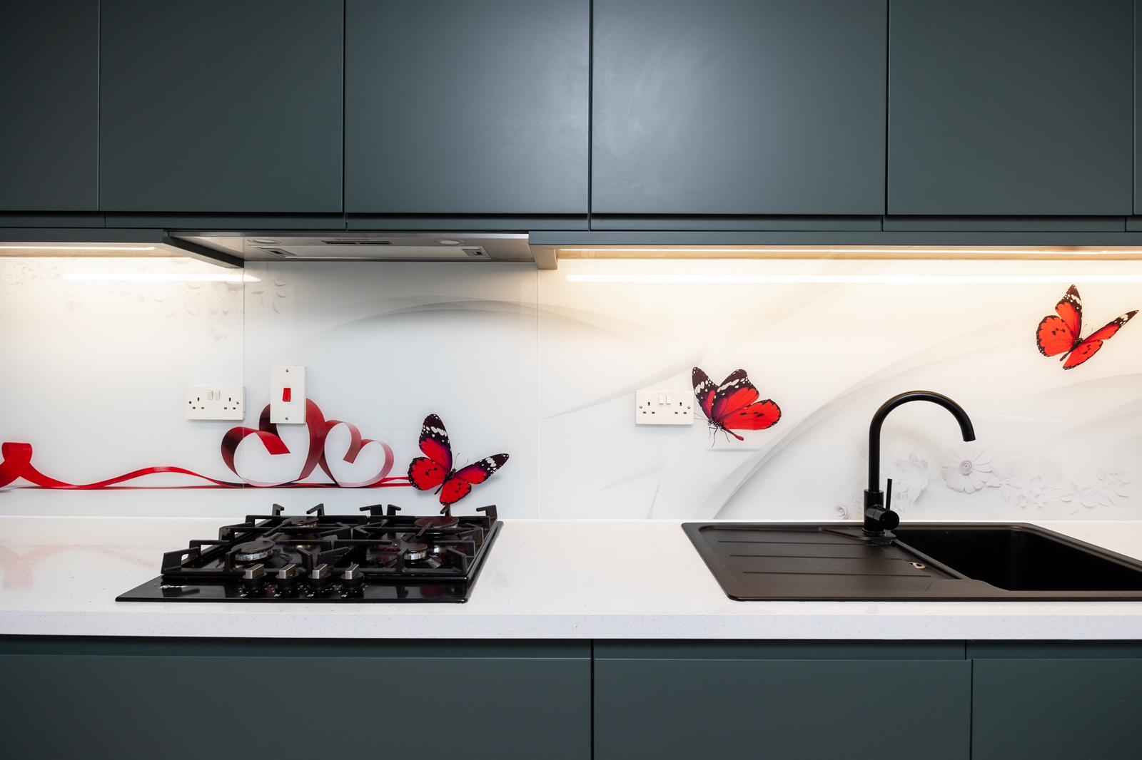 Modern two-story home with large glass windows, warmly lit interiors, and a balcony. Surrounded by trees and a manicured lawn at dusk. Cozy ambiance.