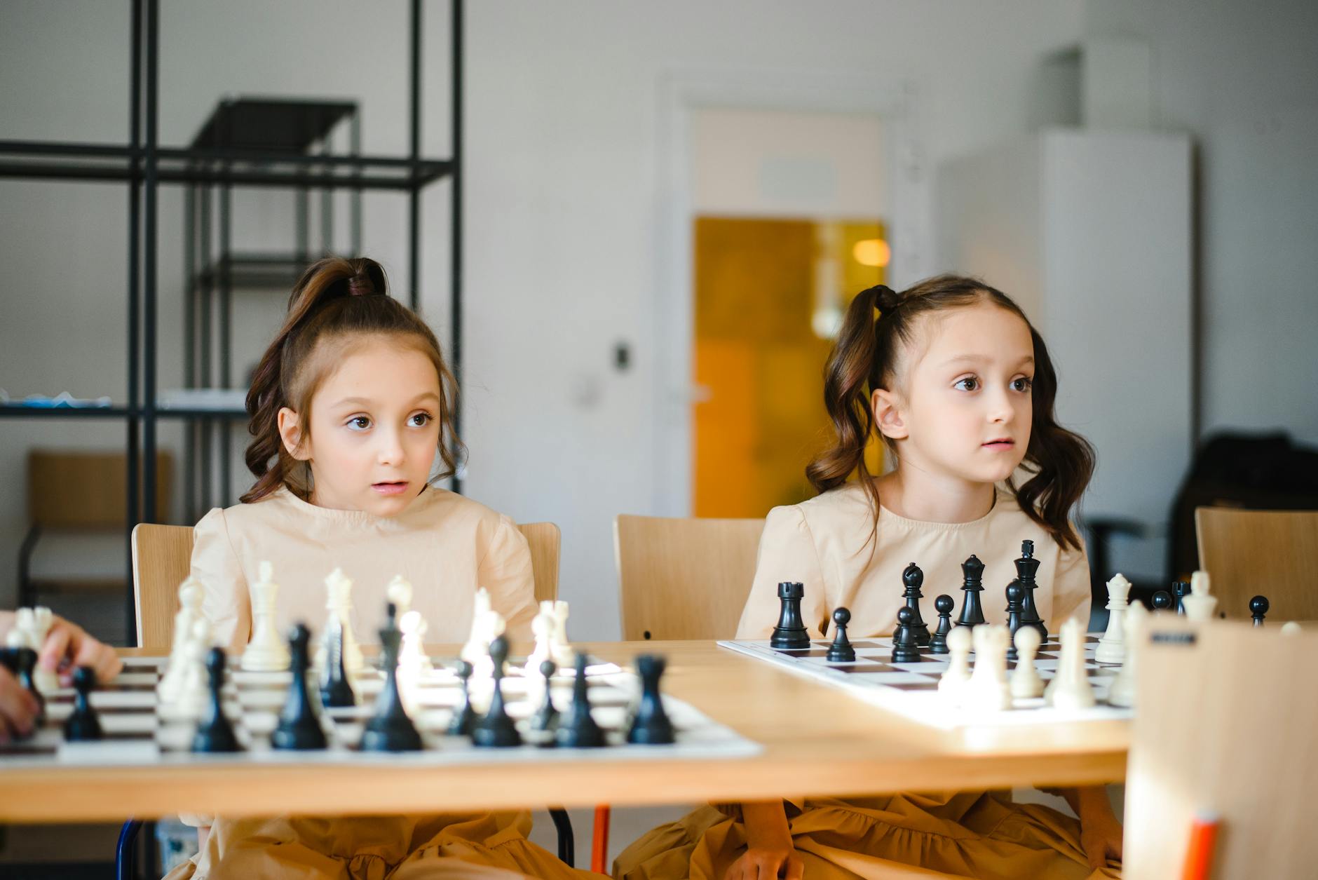 Two young students laughing while playing social emotional learning games with wooden blocks and cards.
