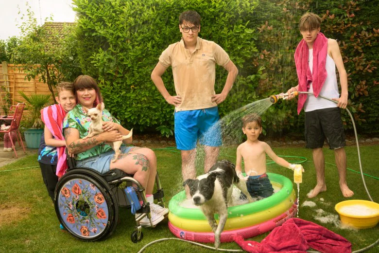 Nina and her 4 boys and two dogs in the back garder on a hot day playing in and around the paddling pool.