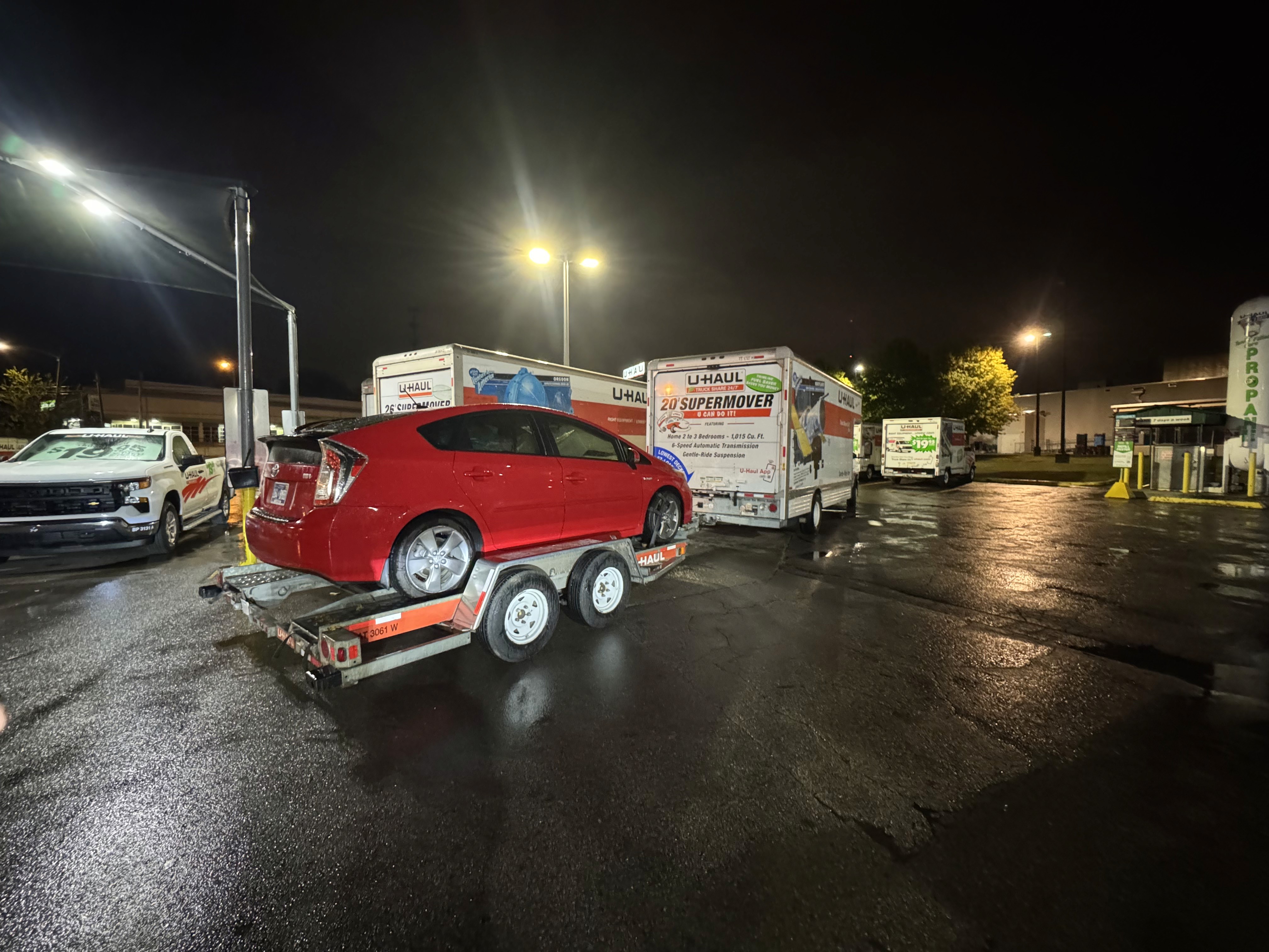 A moving truck towing a car