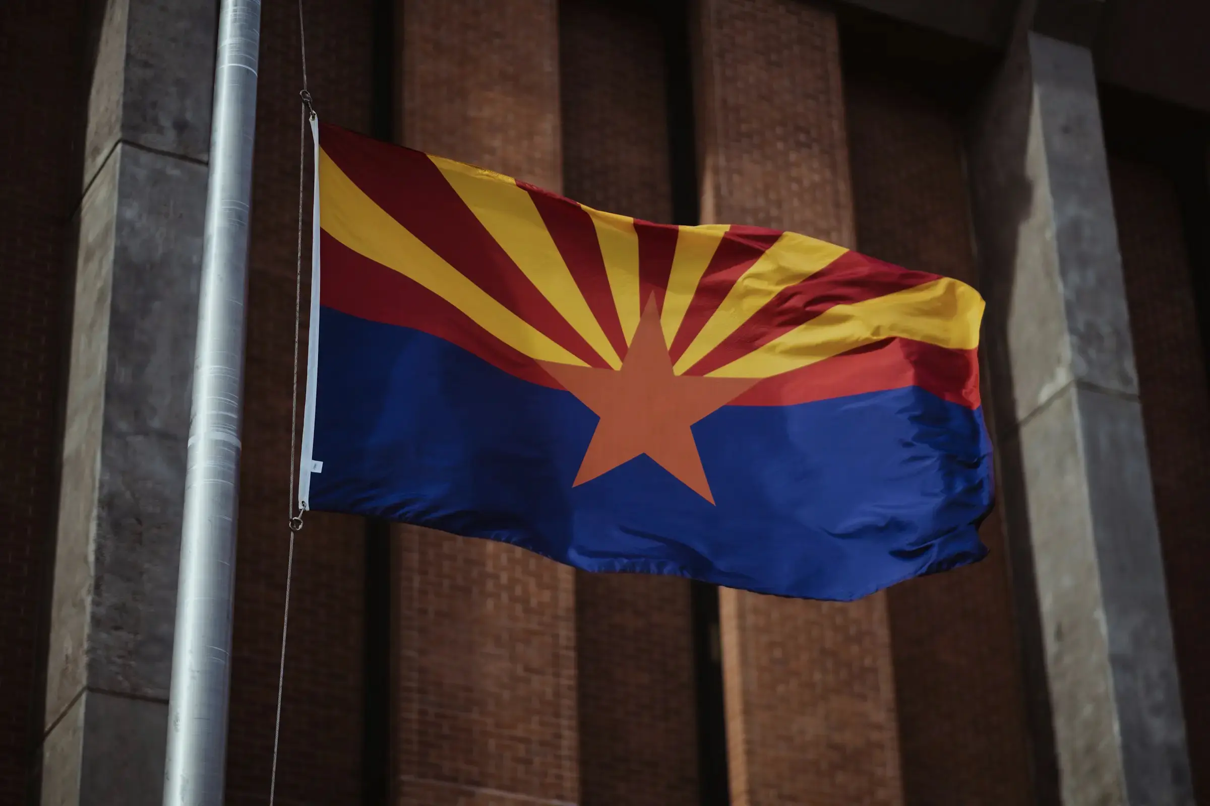 Arizona state flag waving outside a building