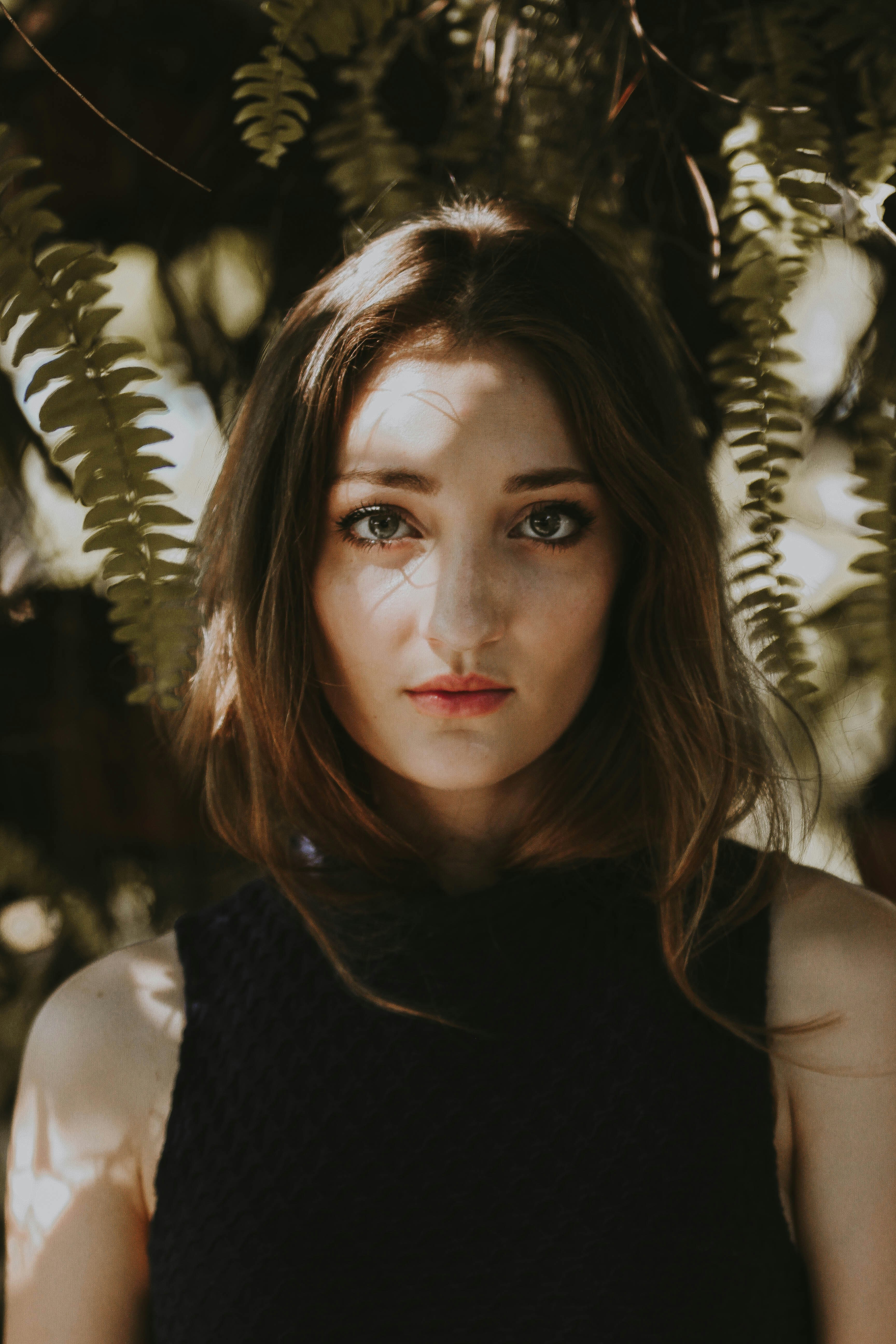 woman standing near fern plant