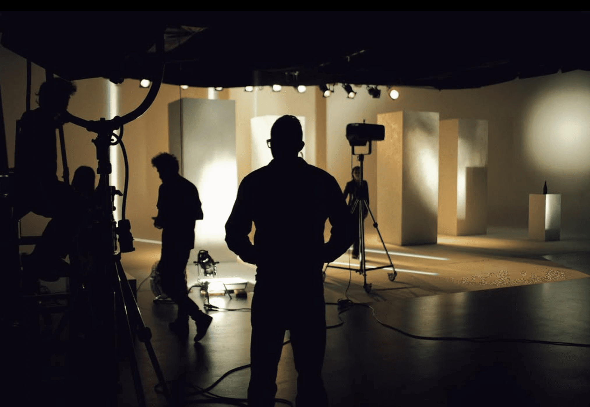 Four diverse professionals collaboratively working on a laptop, with one person pointing at the screen while others observe.