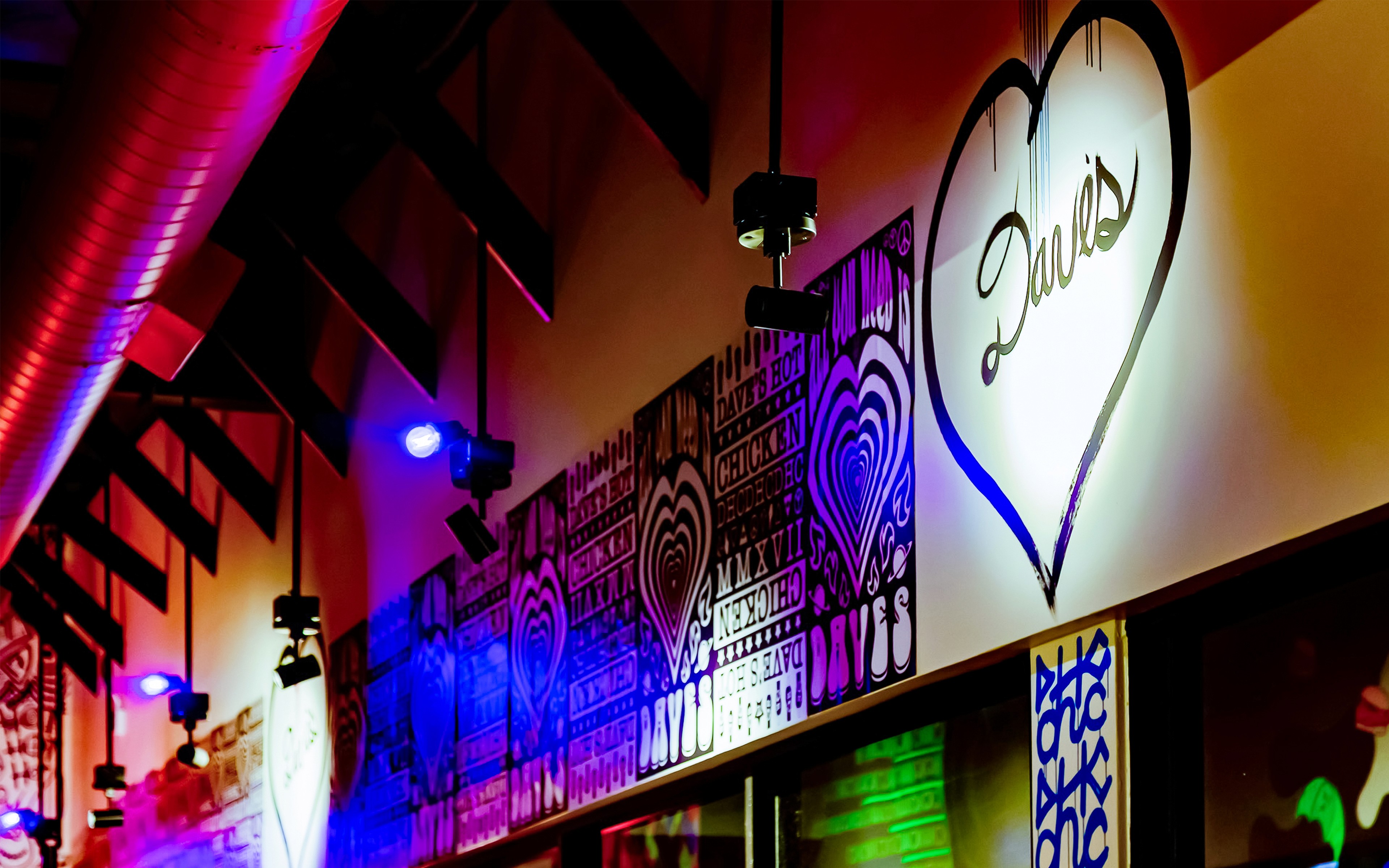 Interior hallway mural with layered typography and heart graphics at Dave’s Hot Chicken Port Hueneme location.