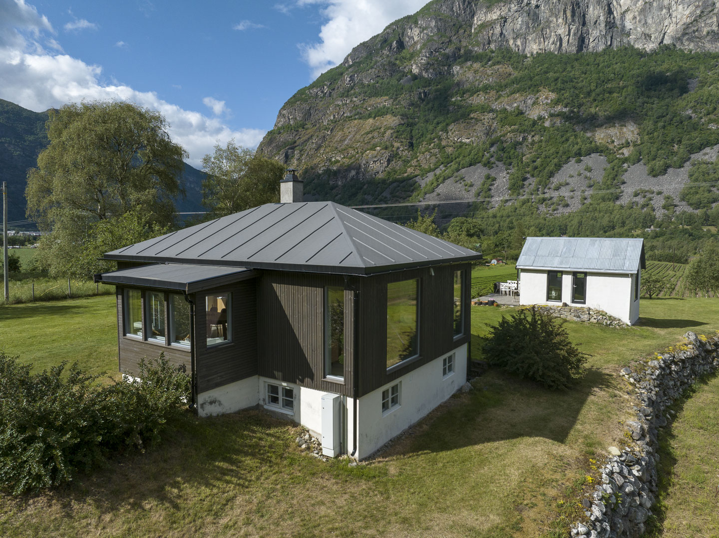 Close-up of dark green velvet dining chairs around a white table with decorative accents