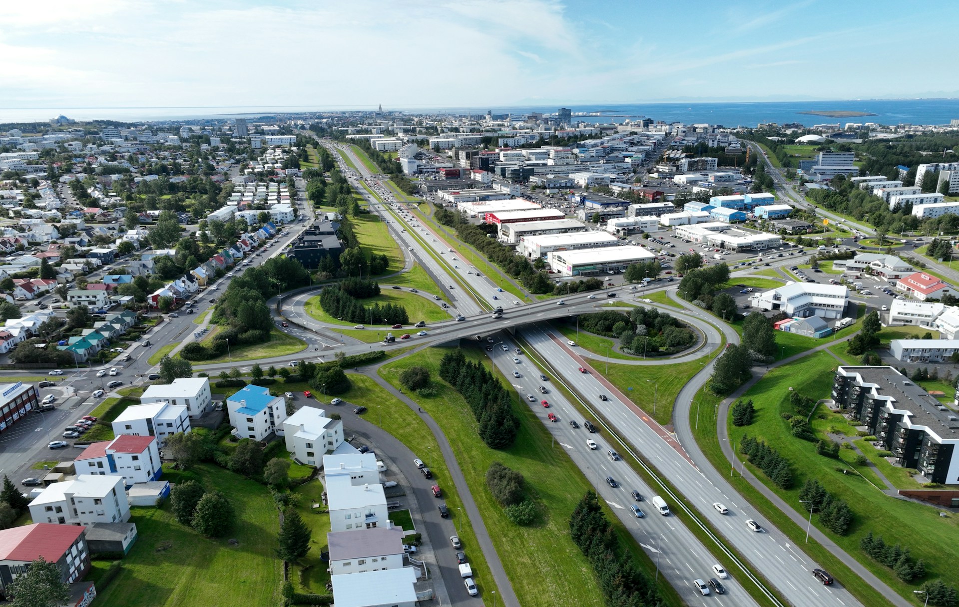 Aerial view of Reykjavík showing major roads, neighborhoods, and the city stretching toward the coastline.