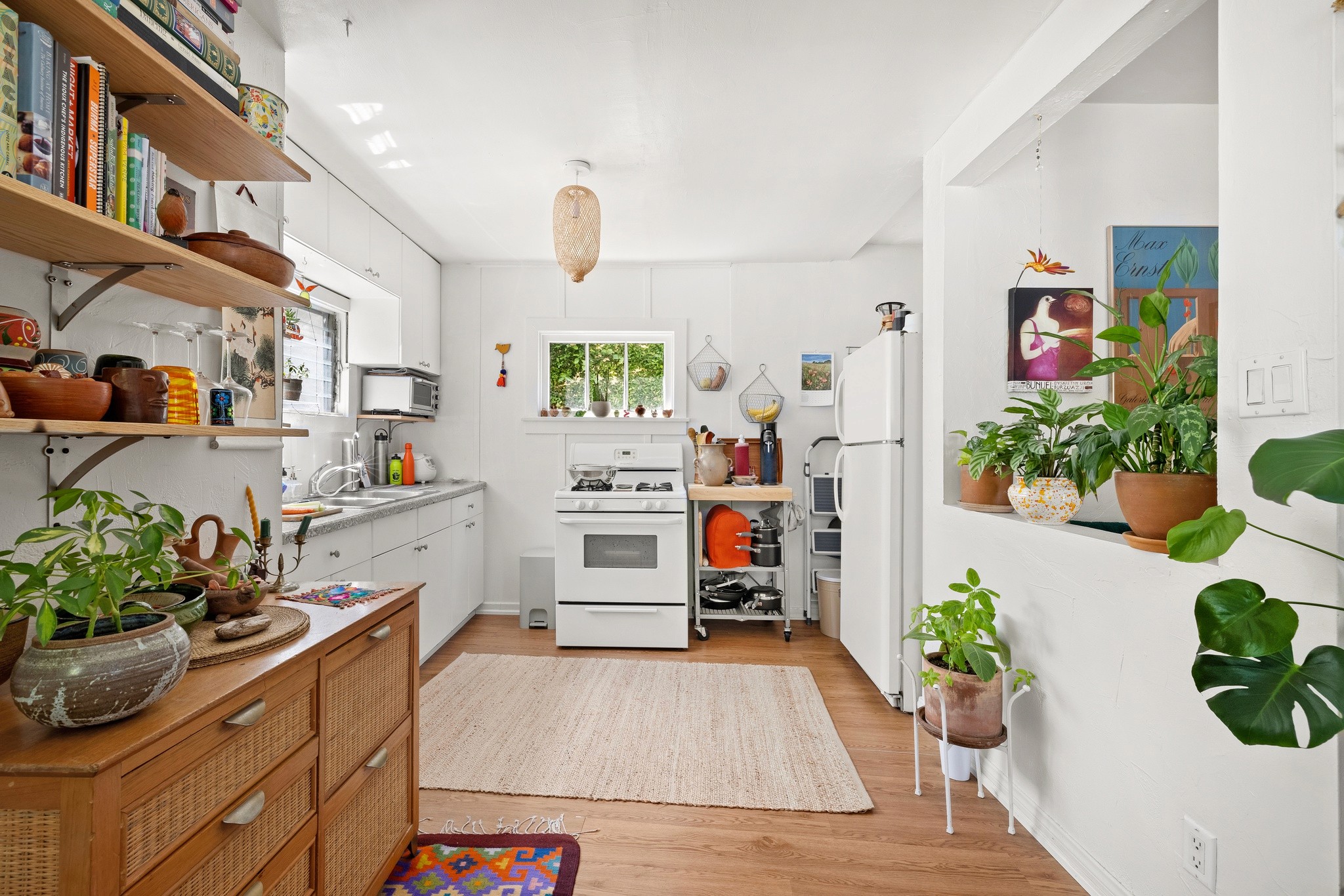 Bright kitchen at 3456 plata, with wooden shelves, plants, and appliances, featuring a cozy and inviting atmosphere.