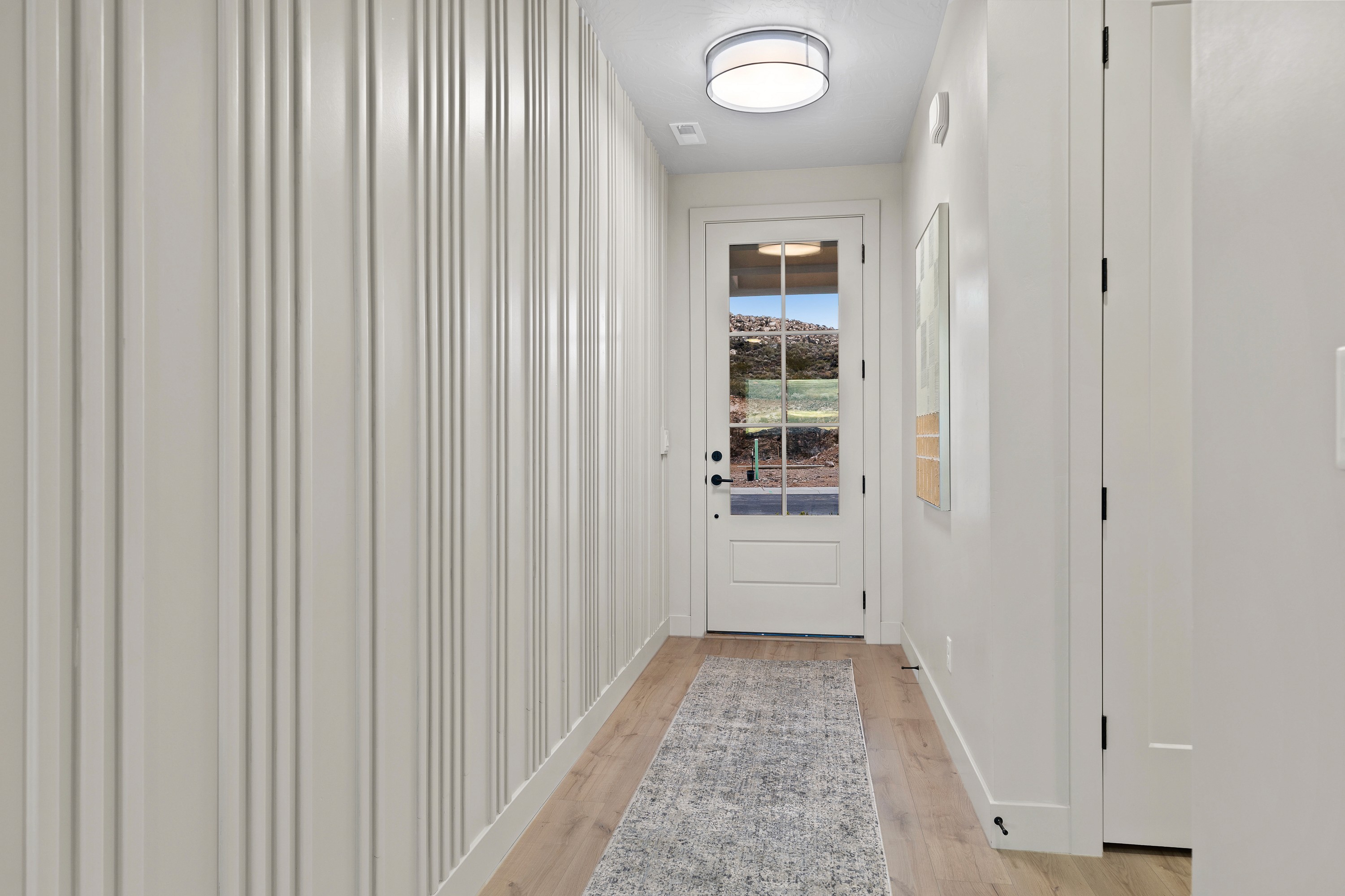 Entry accent wall inside The Painted Horizon twin home in Hurricane, Utah featuring custom design details that create a welcoming first impression.
