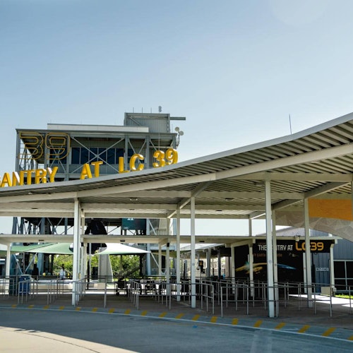 Outdoor structure with a canopy and signage reading "The Gantry at LC 39." Empty metal railings and building in the background.