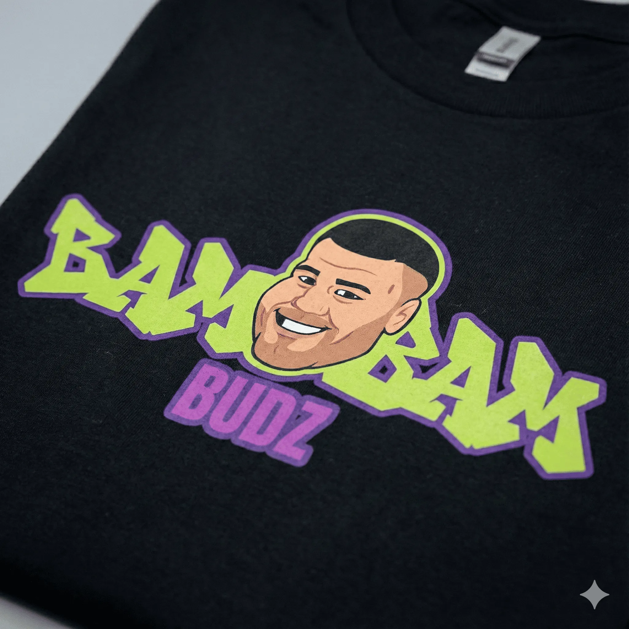 Close-up fabric texture showcasing the BamBam Budz graffiti logo and cartoon face.