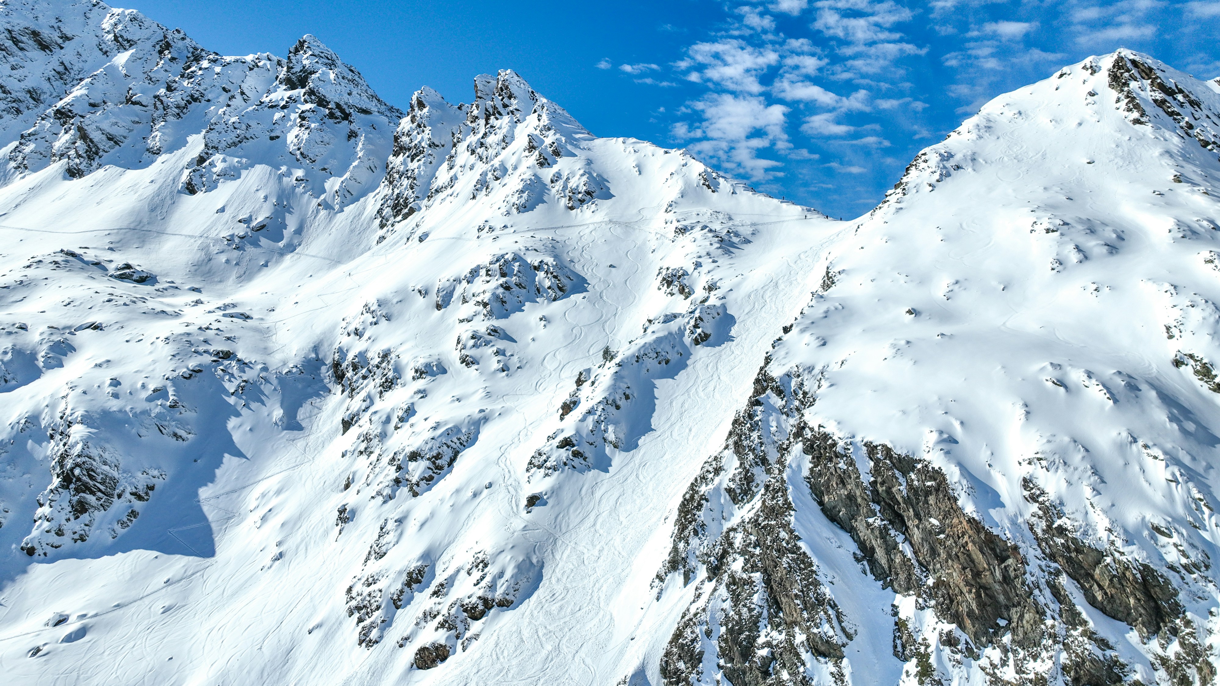 A snow covered mountain range under a blue sky