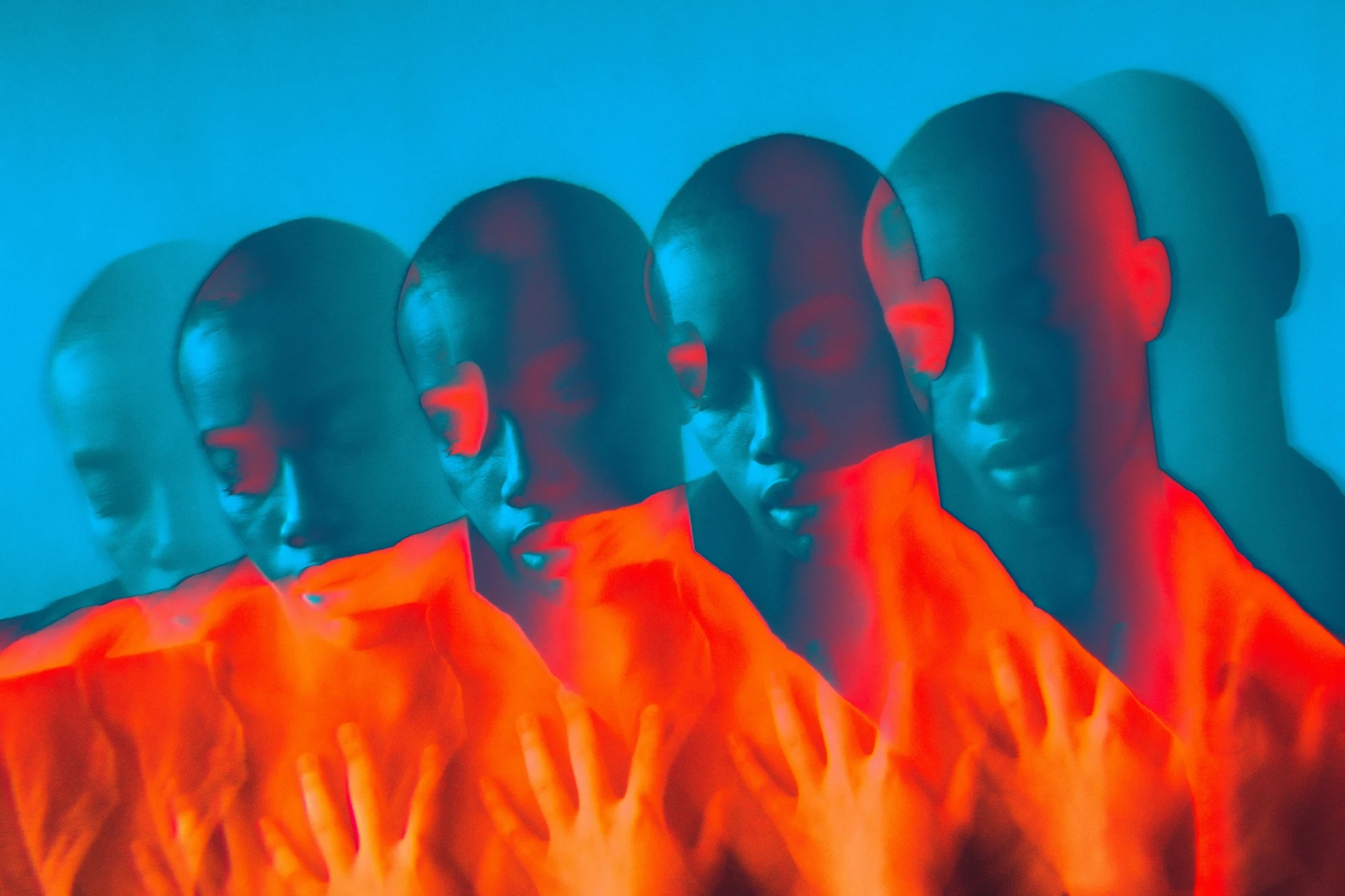 Mehrfach überlagerte Darstellung eines menschlichen Gesichts und von Händen in intensiven Blau- und Rottönen, abstrakte, digital wirkende Lichtkomposition.
