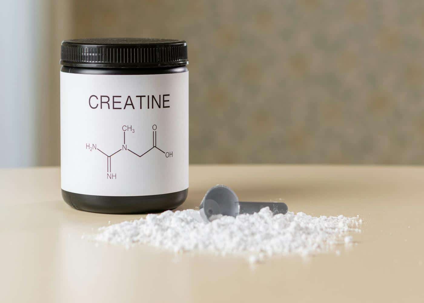 Effects of creatine on the body - image of a creatine bottle next to powdered creatine