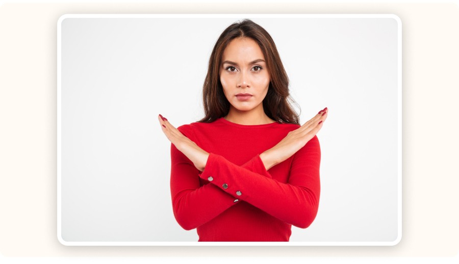 Femme croisant les bras en geste refus portant pull rouge