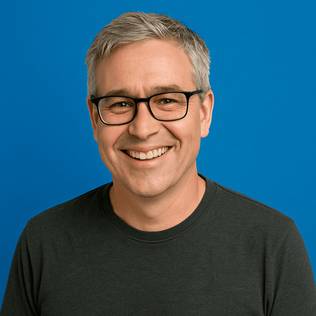 man wearing blue button-up denim jacket sitting beside green fence