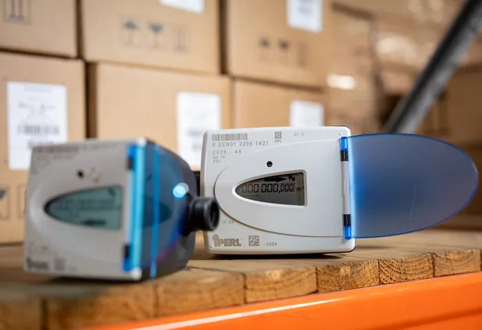 Two Sensus iPERL smart water meters on a shelf in the JOAT warehouse