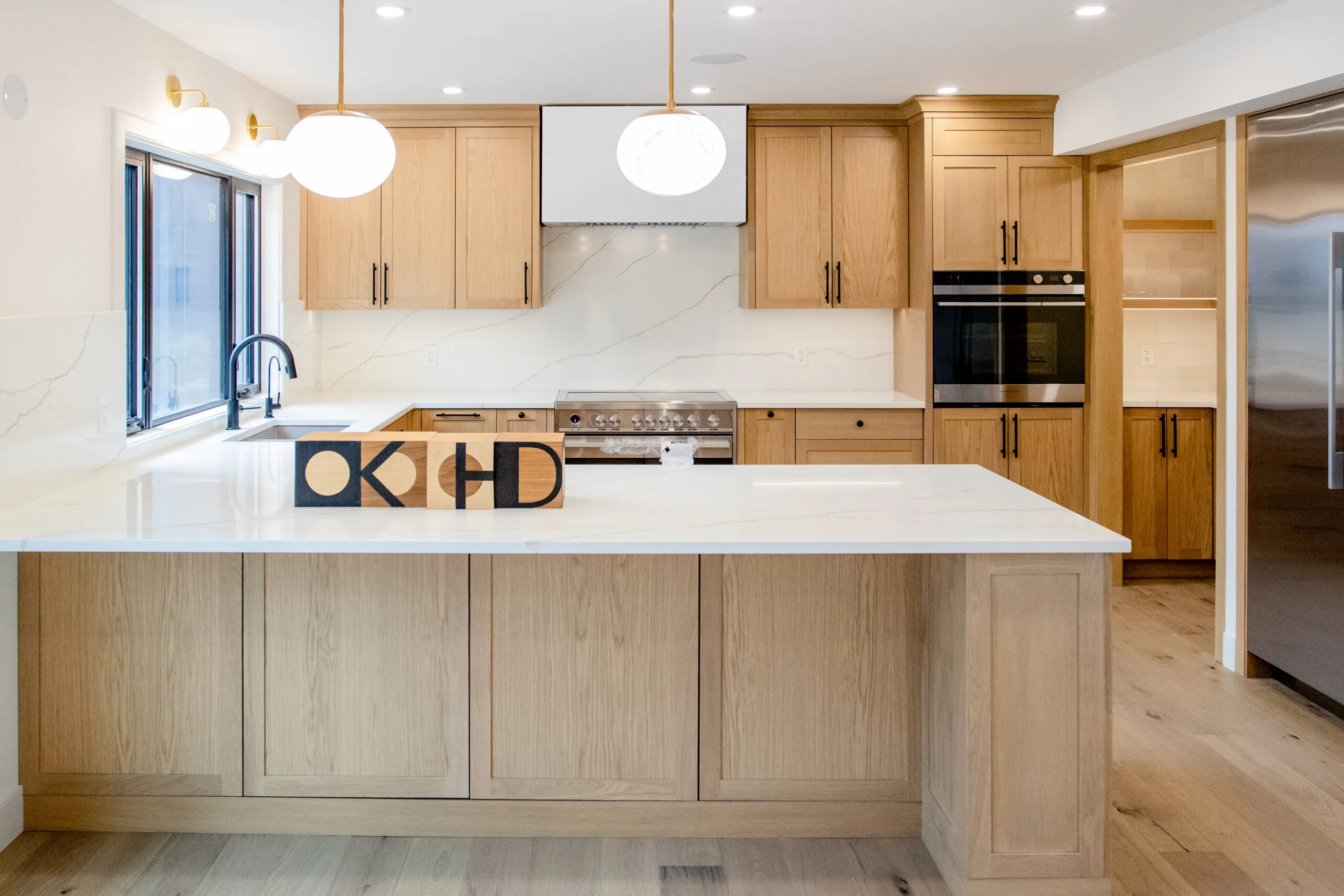 Image of warm kitchen with white countertops and the KHD wooden blocks sitting on the peninsula island.
