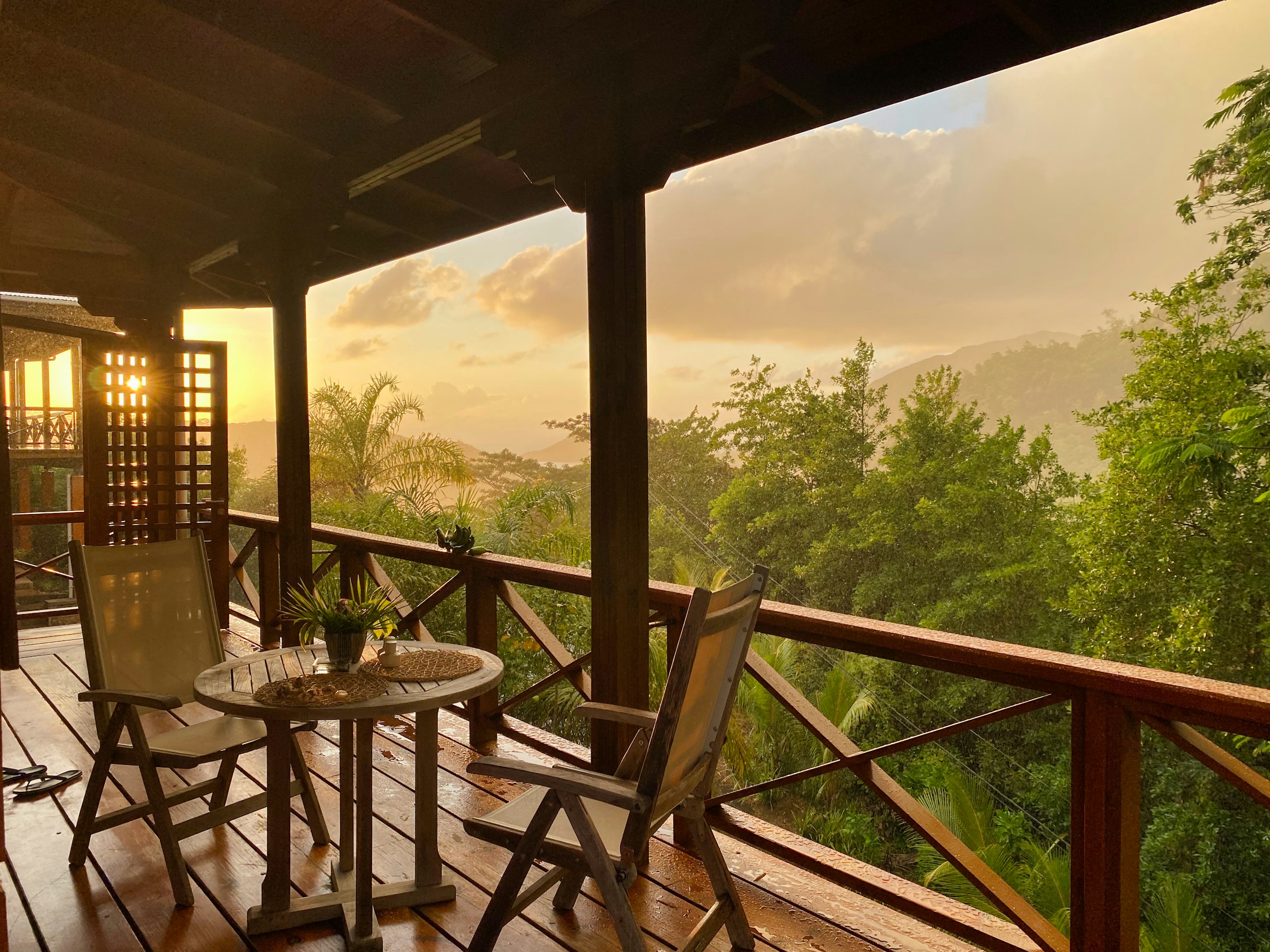 Private balcony with two chairs overlooking serene nature in the morning light