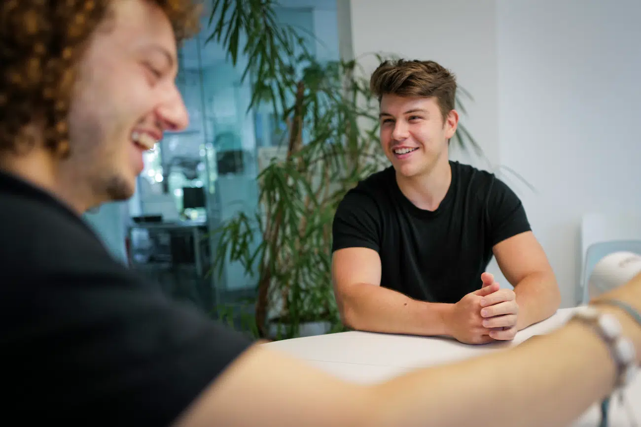 Our founders Samuel and Thiago in a modern meeting space engaged in conversation, symbolising collaboration and innovation. This image introduces CoachingArea's podcast focused on sharing visionary ideas, innovative solutions, and strategies that shape the future of sport, from coaching practices to SportsTech advancements.