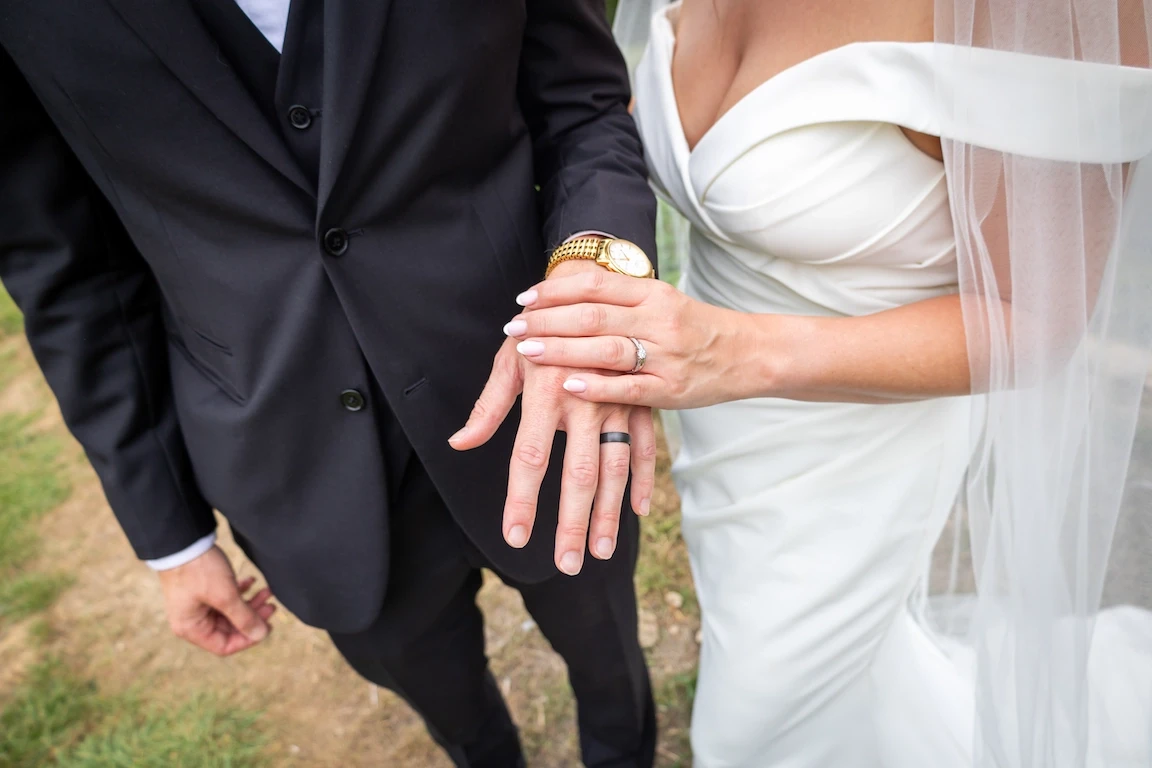 Close-up of Charlotte and Chris showing their wedding rings at The Great Barn Aynho