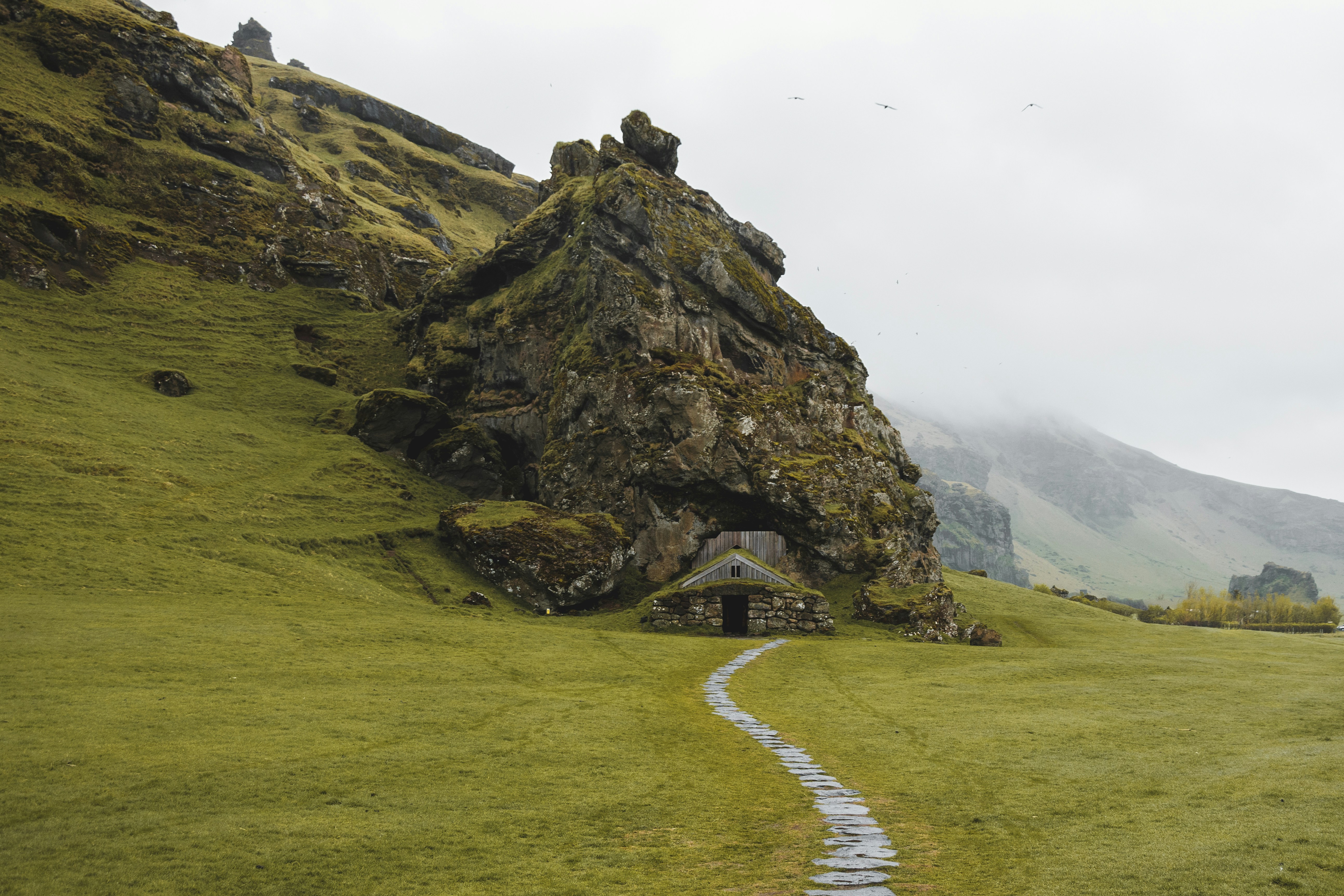 Entrance to Rútshellir Cave set into a grassy hillside in South Iceland.