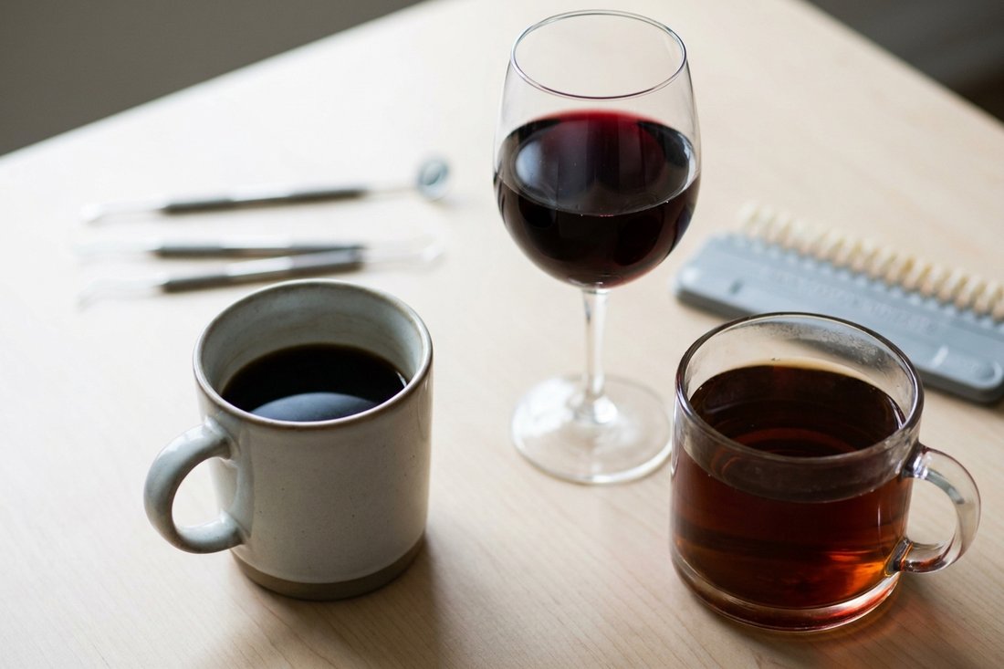 Coffee, red wine, and tea on a table representing drinks that stain teeth
