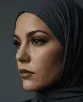 A close-up, profile portrait of a woman with a contemplative expression, looking off-camera. She is wearing a dark charcoal-grey jersey hijab. Her makeup is sophisticated and defined, featuring sharp winged eyeliner, groomed eyebrows, and matte mauve lipstick. The image is shot against a solid, muted dark background with soft, directional lighting that highlights her facial features.