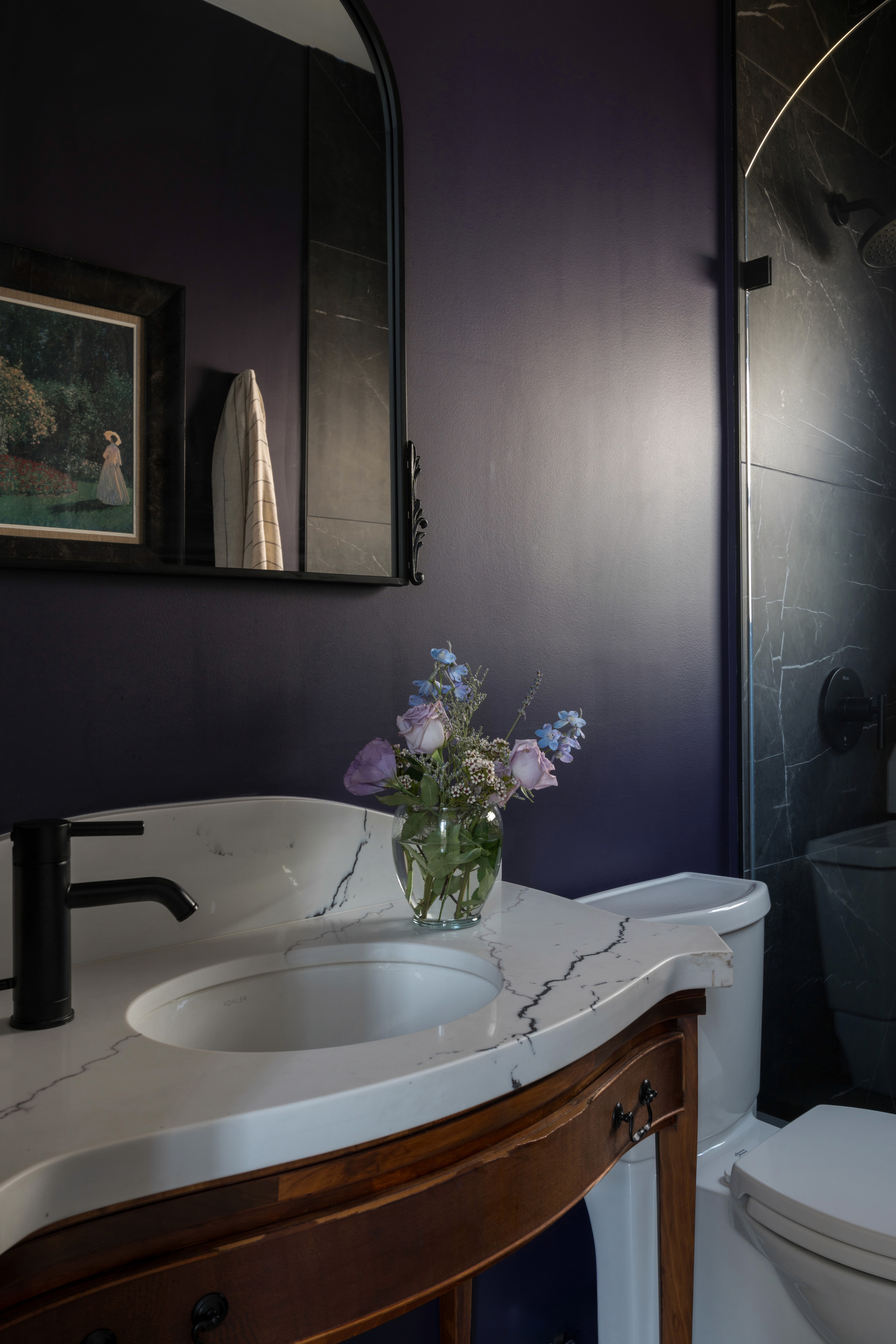 A bold and playful guest bathroom featuring deep purple walls. The space includes a modern vanity creating a vibrant yet sophisticated look by Jubilee Interiors in Lakewood, California