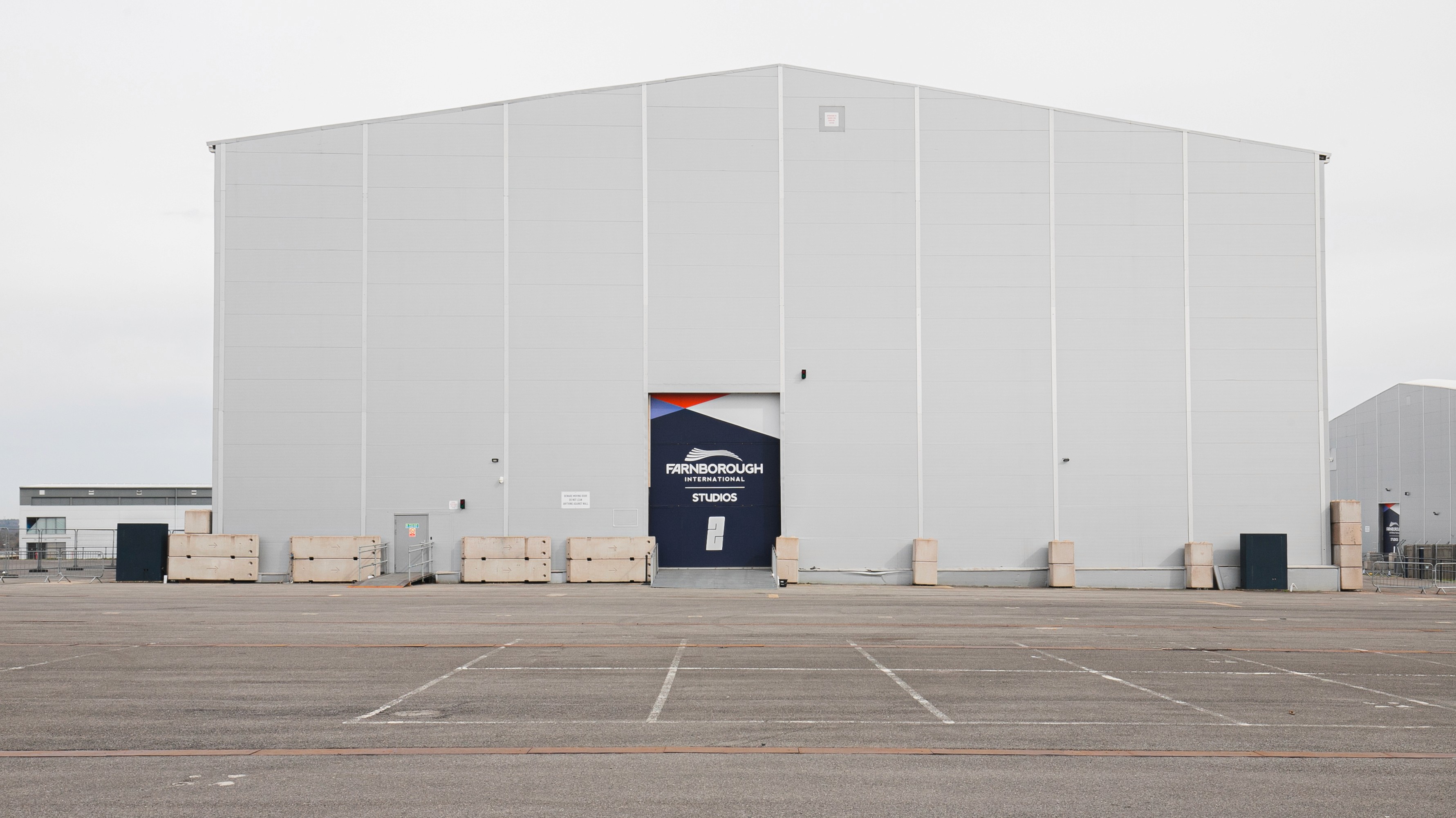 Two classic volkswagen beetles, one green, one cream.