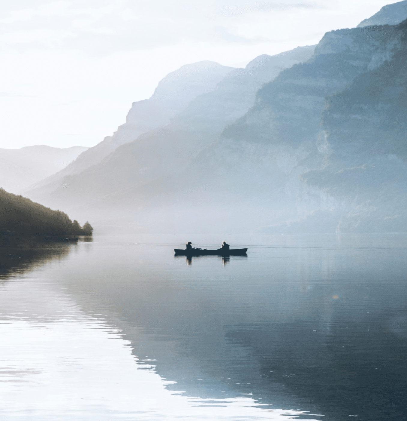 2 man sitting in boat in a misty lake